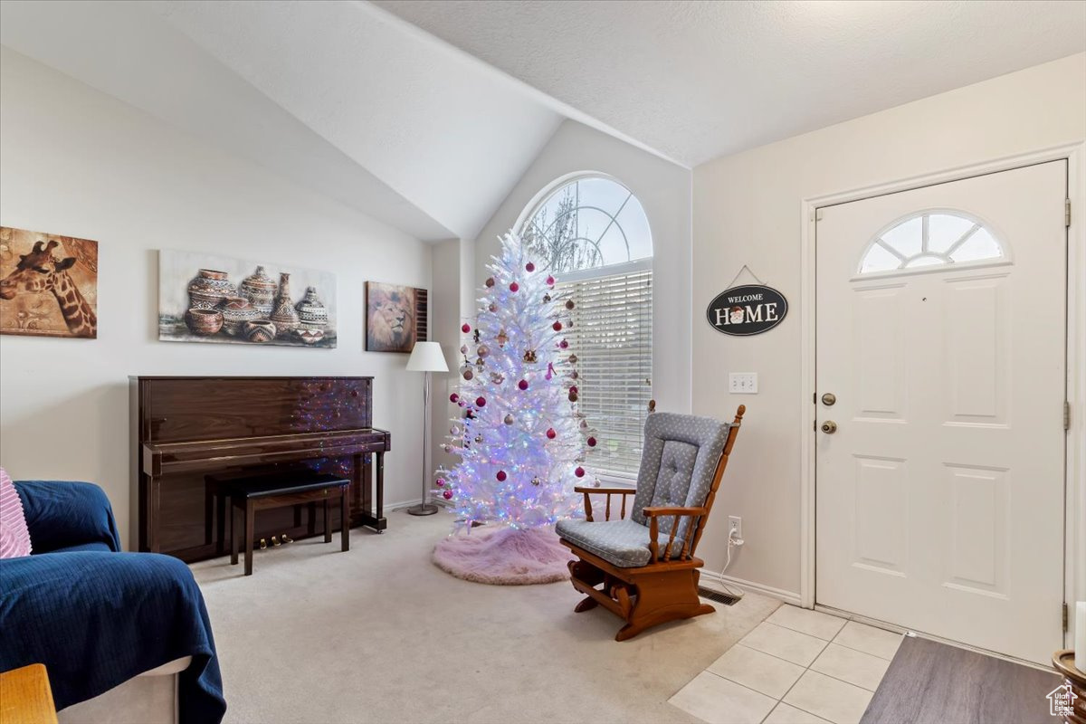 Carpeted entrance foyer with a wealth of natural light and vaulted ceiling