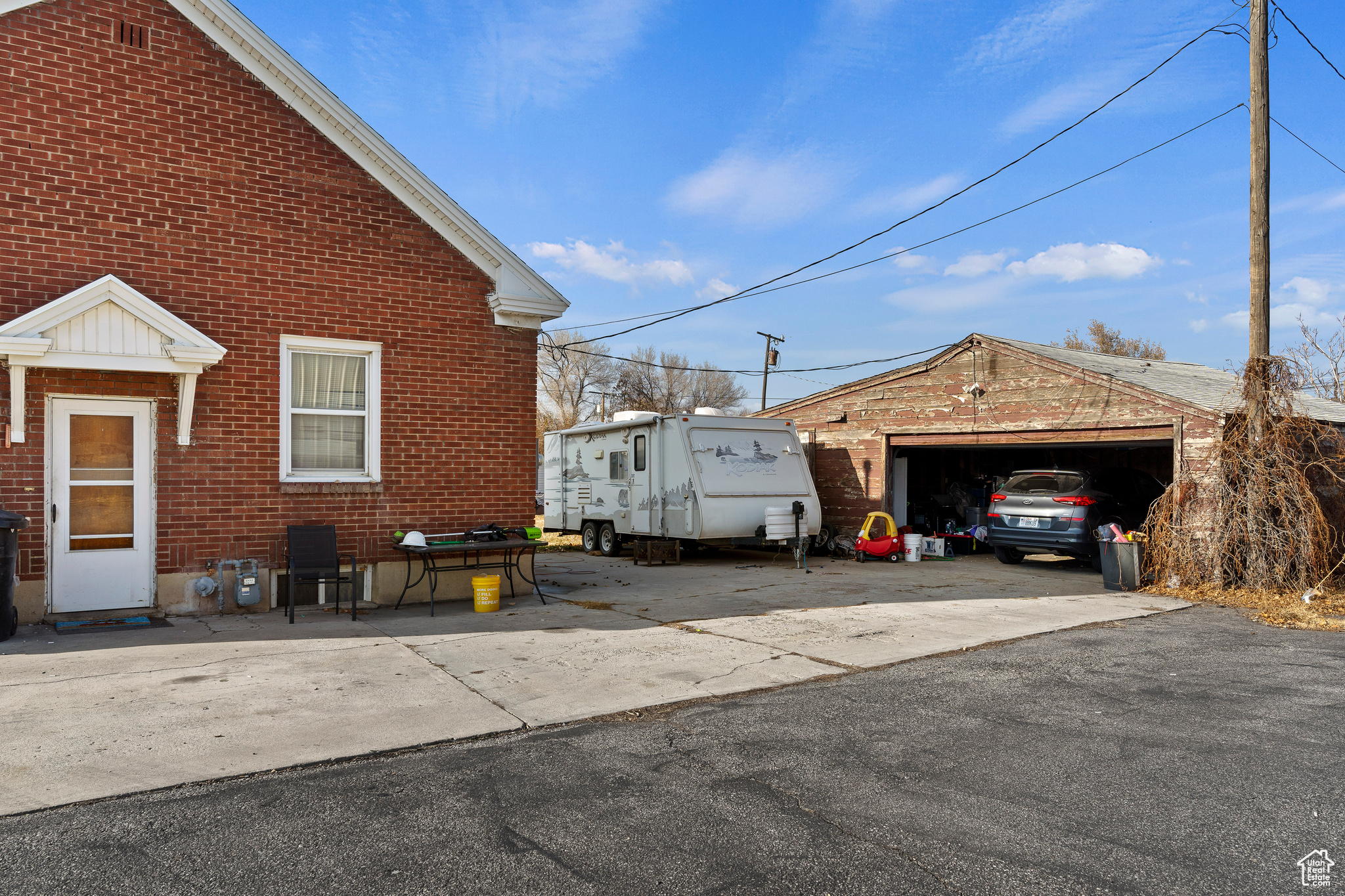 View of side of home with a garage and an outbuilding