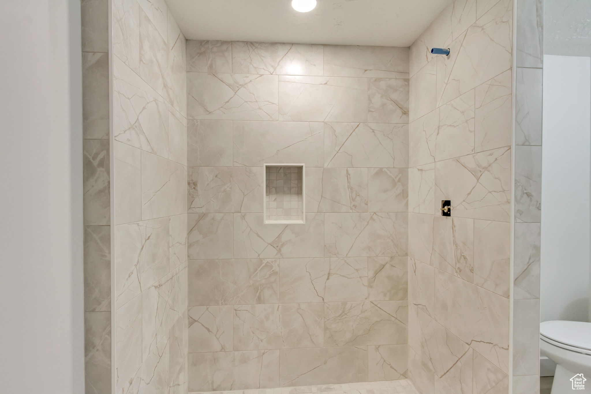 Bathroom featuring toilet and tiled shower