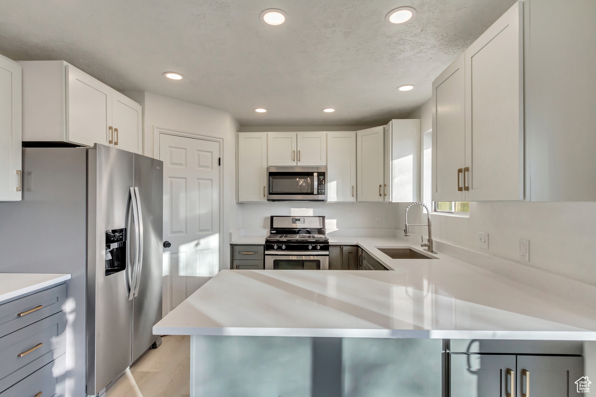 Kitchen with stainless steel appliances, kitchen peninsula, and gray cabinets