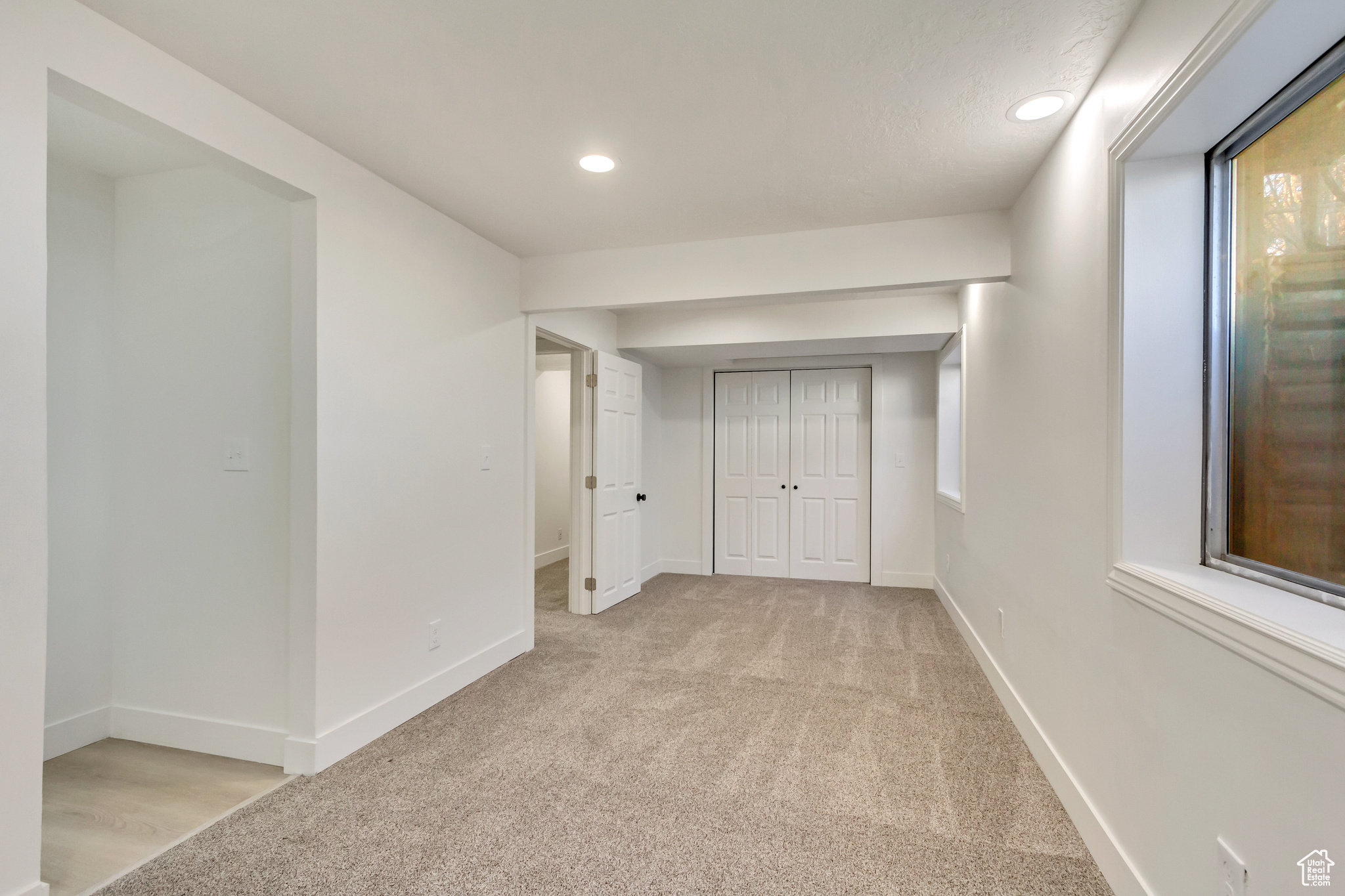 Hallway featuring light colored carpet