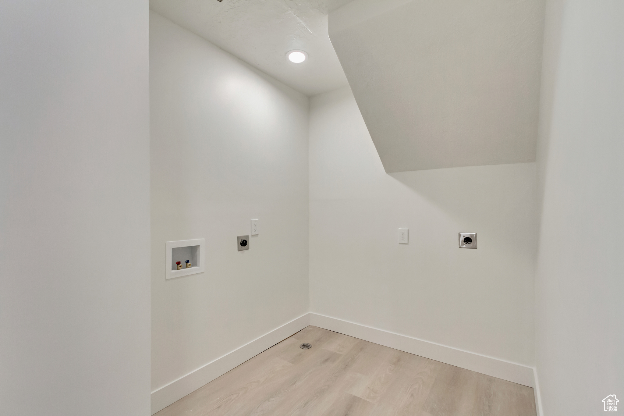 Laundry room with washer hookup, hookup for an electric dryer, and light wood-type flooring