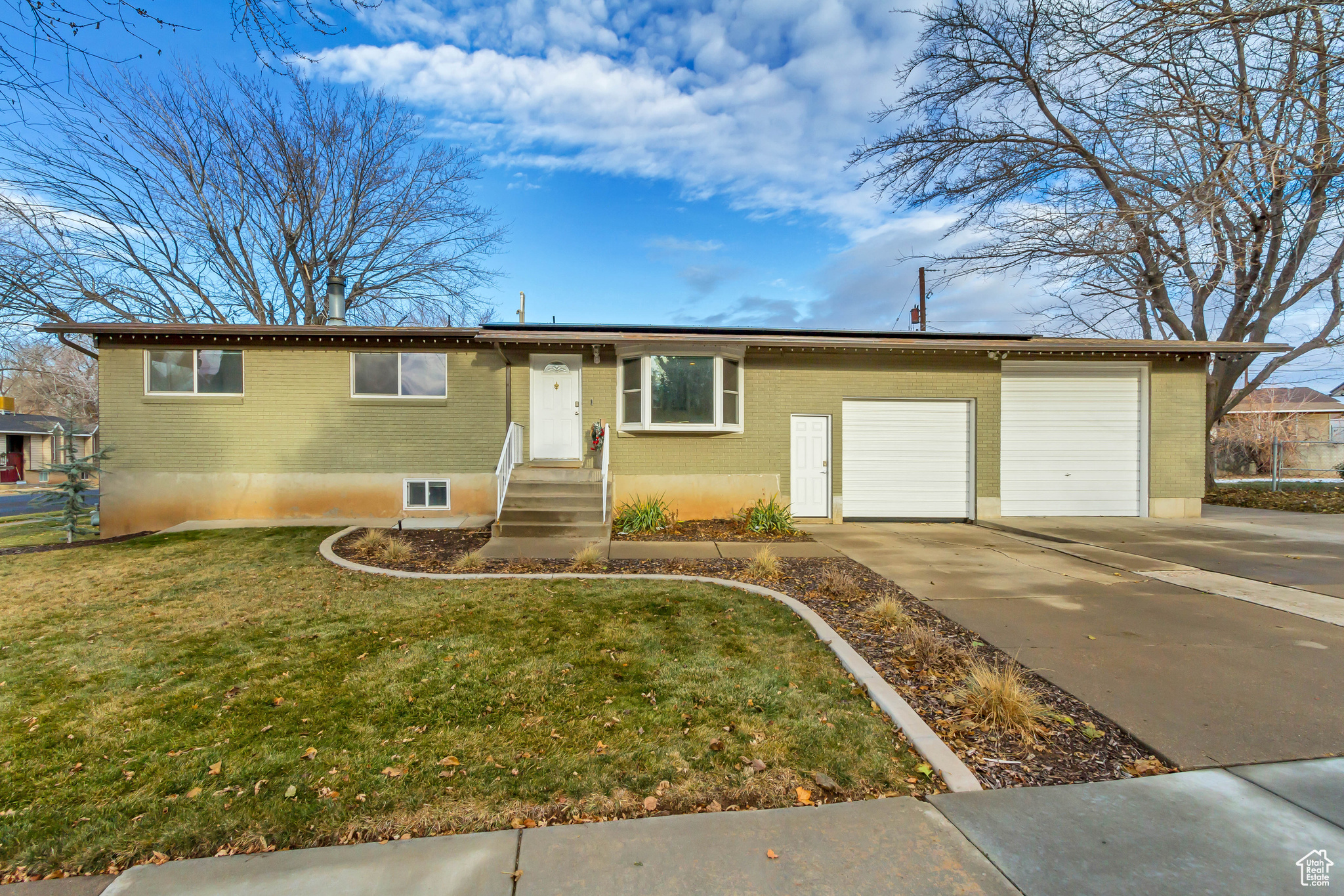 View of front of home with a garage and a front lawn