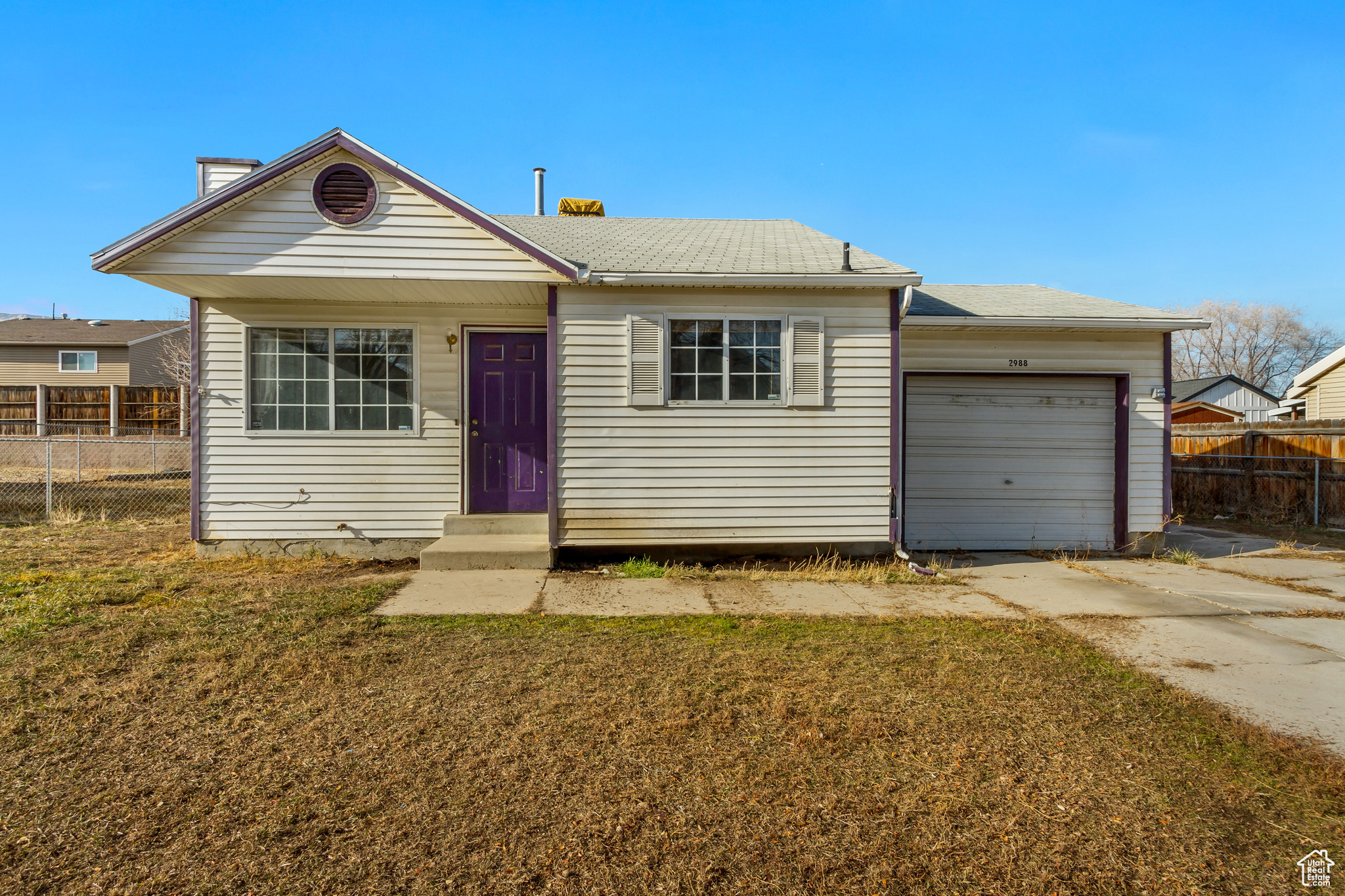 View of front of property featuring a garage and a front lawn