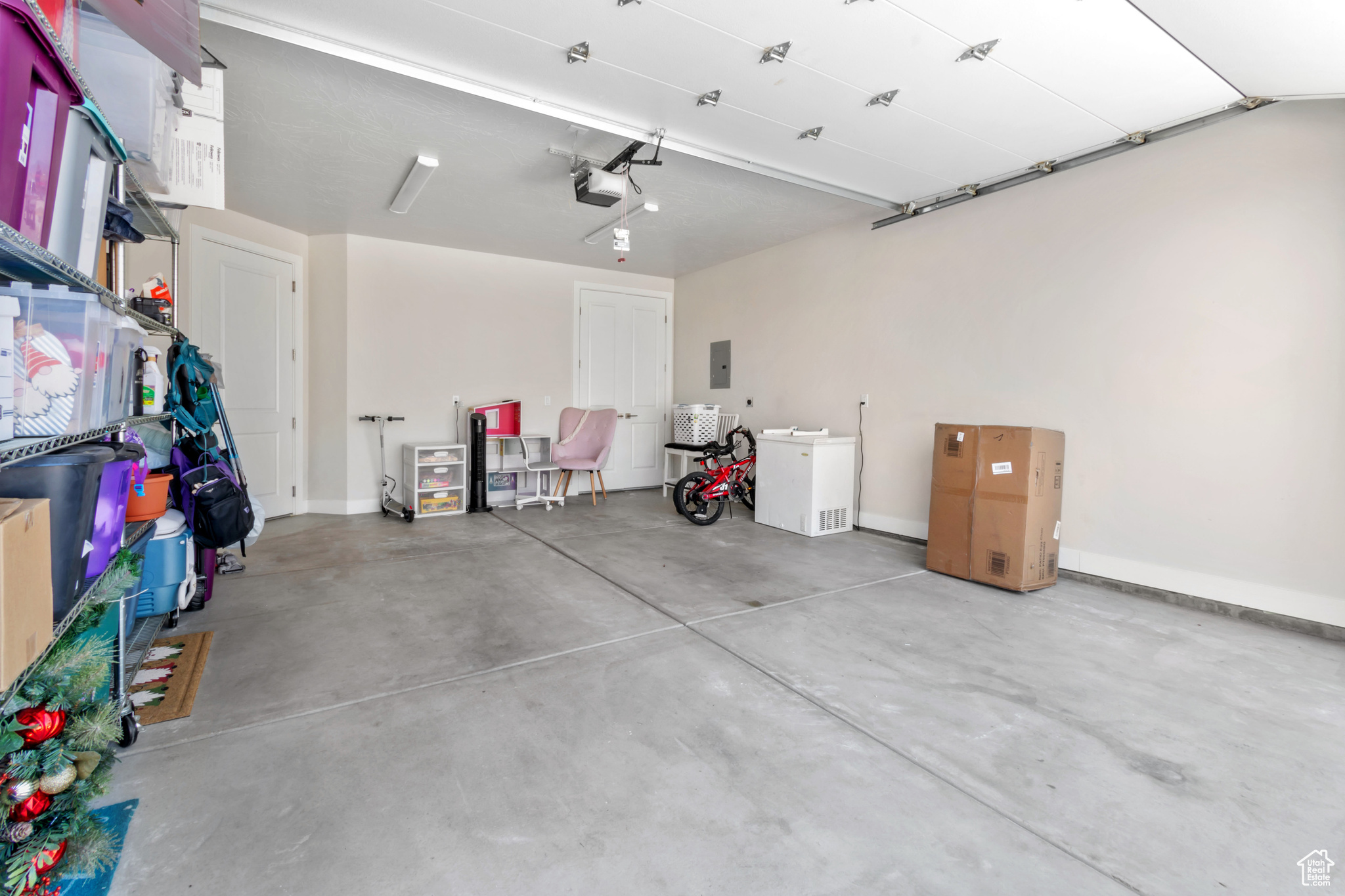 Garage featuring electric panel and a garage door opener