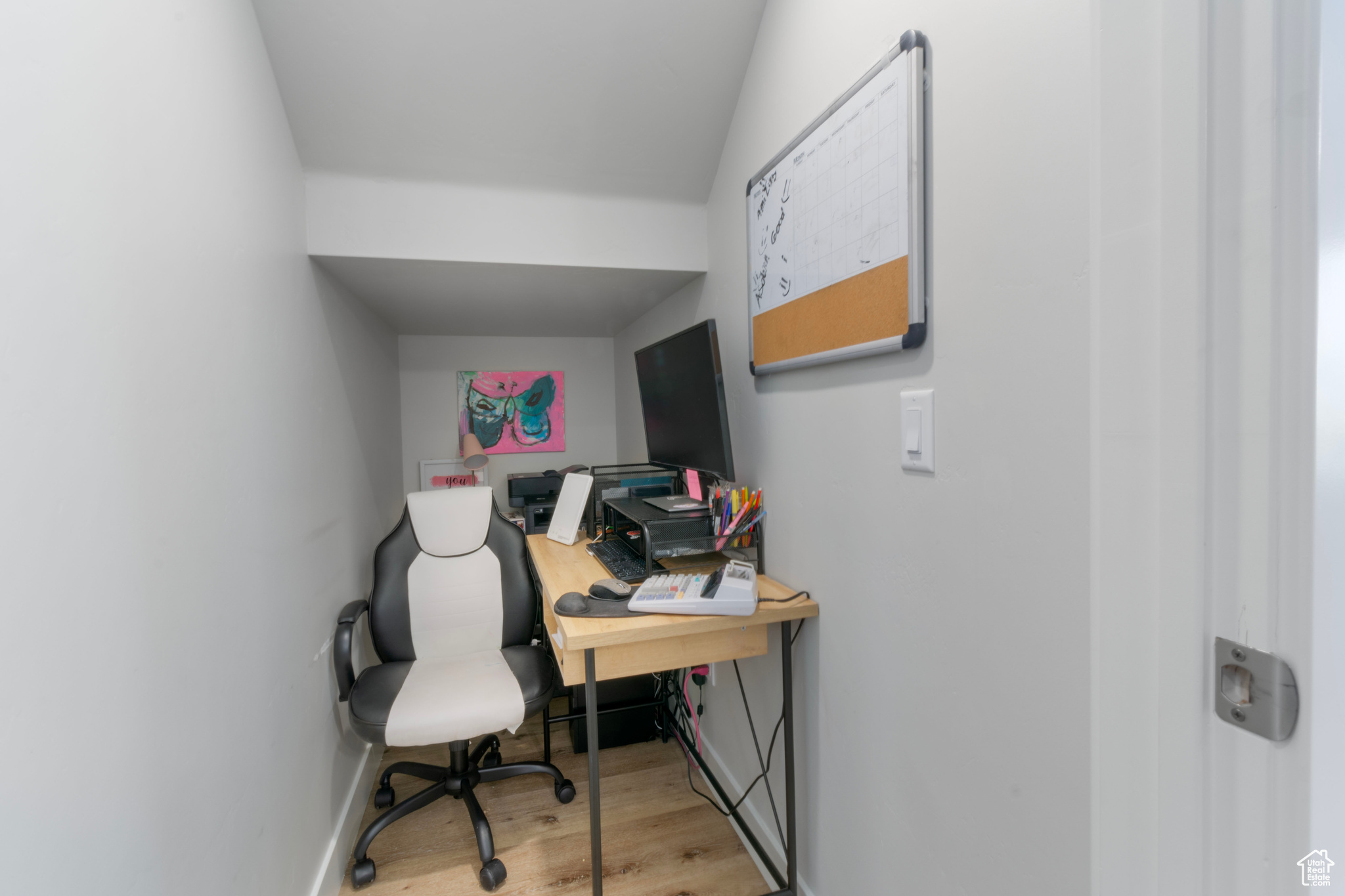 Office space featuring light hardwood / wood-style floors and lofted ceiling