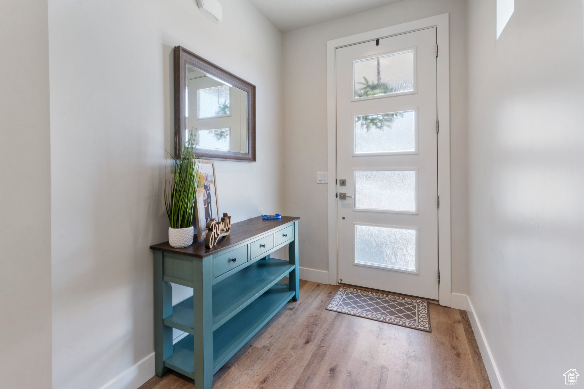 Doorway with light hardwood / wood-style floors