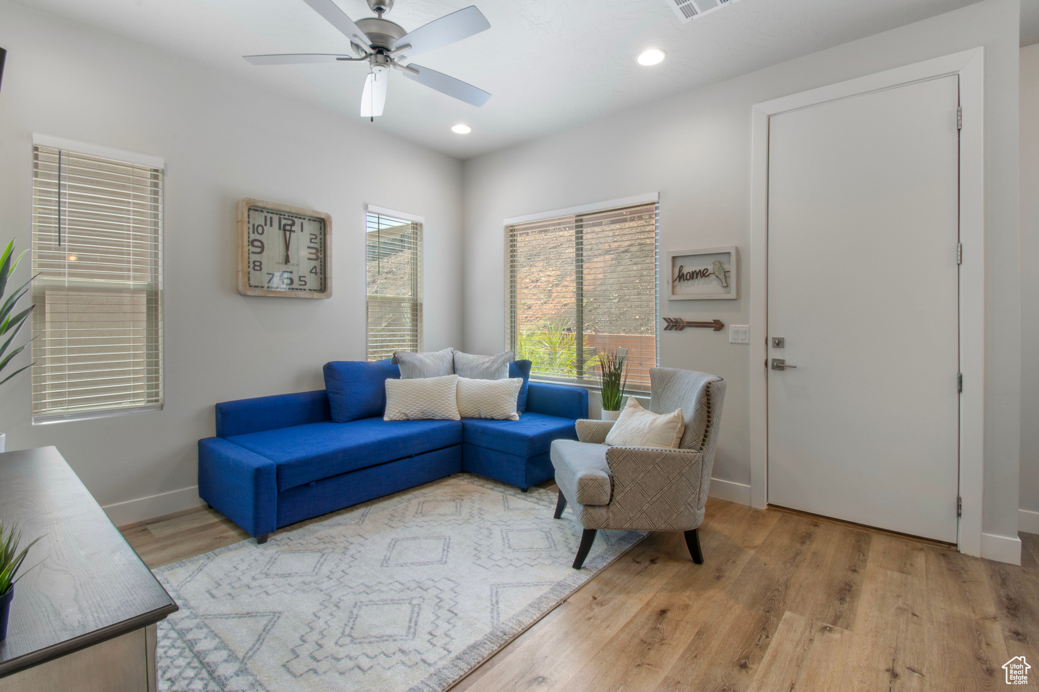 Living room with ceiling fan and light hardwood / wood-style floors