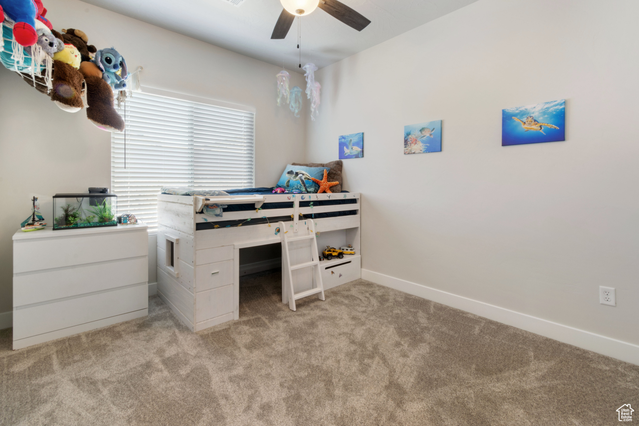 Carpeted bedroom featuring ceiling fan