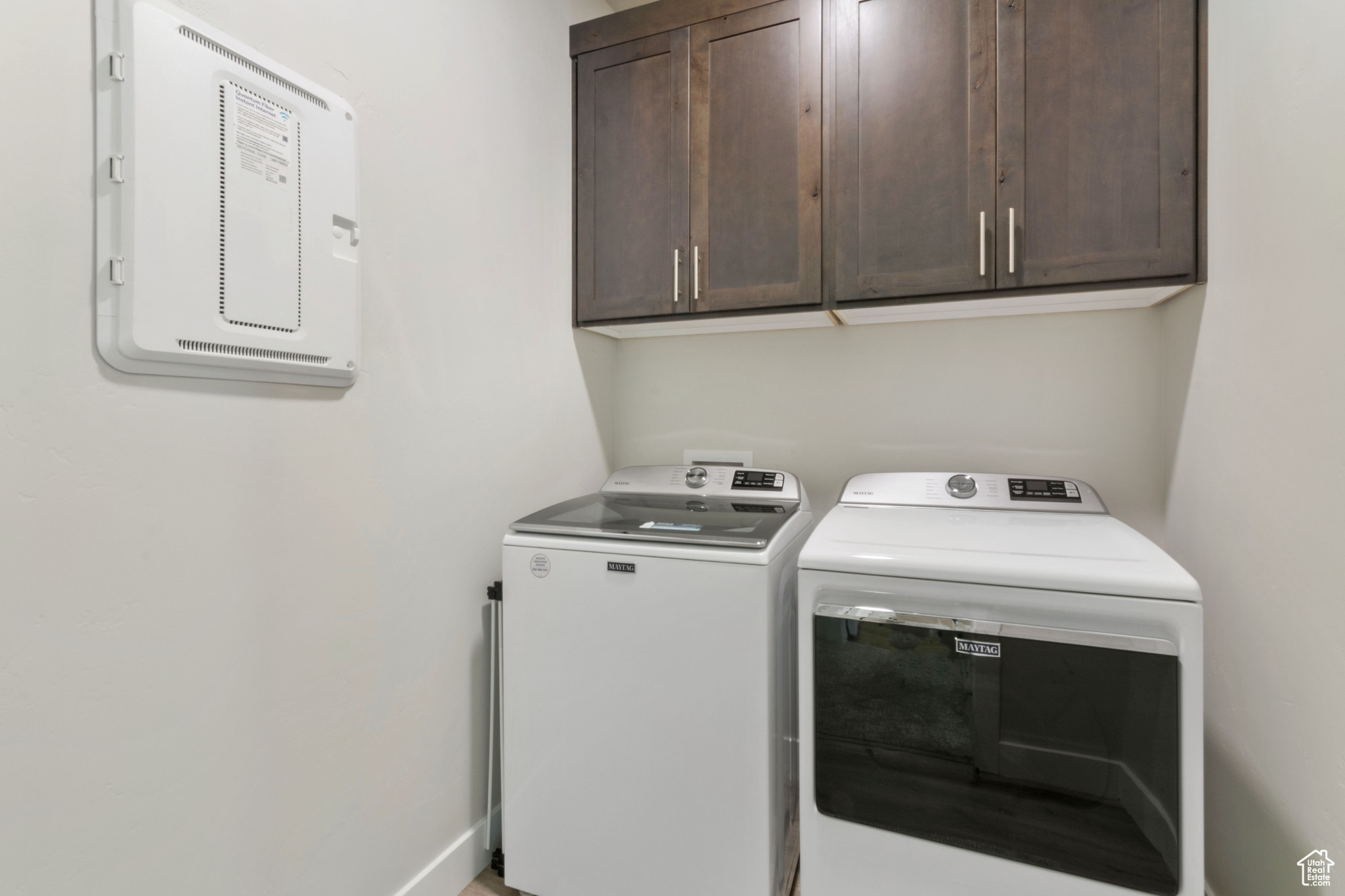 Laundry area with washer and clothes dryer and cabinets