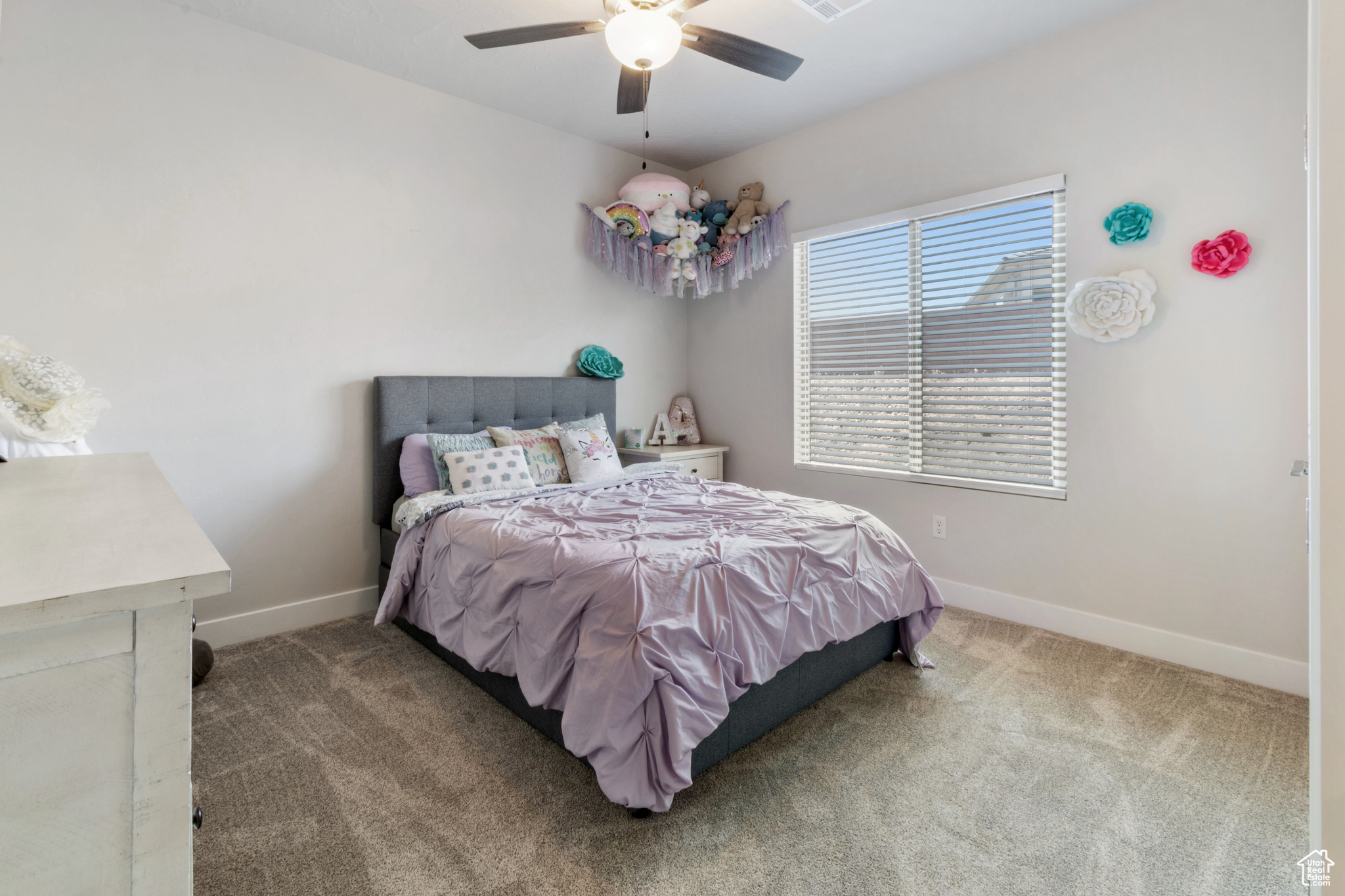 Carpeted bedroom featuring ceiling fan