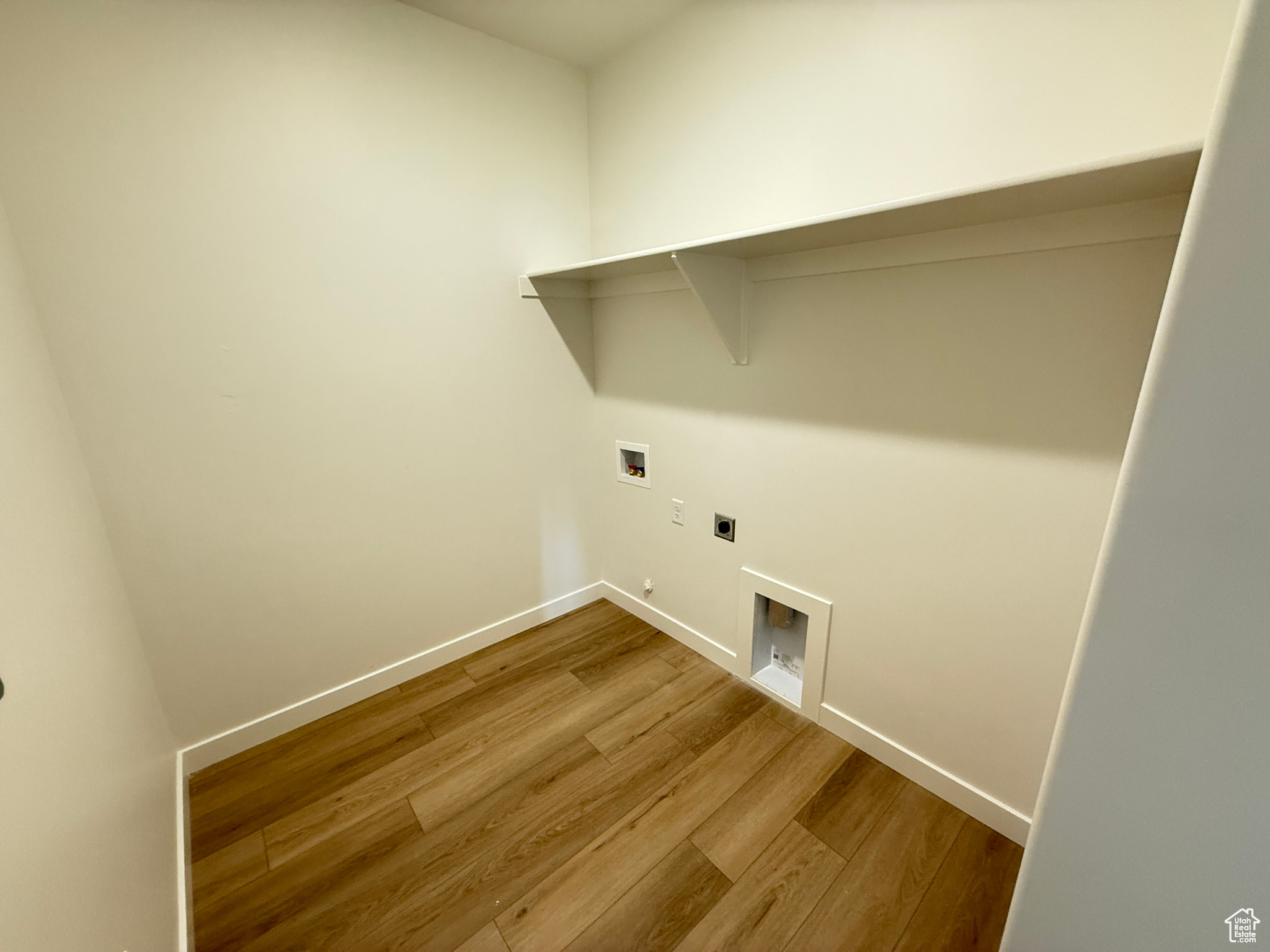 Laundry room featuring gas dryer hookup, hookup for a washing machine, wood-type flooring, and hookup for an electric dryer