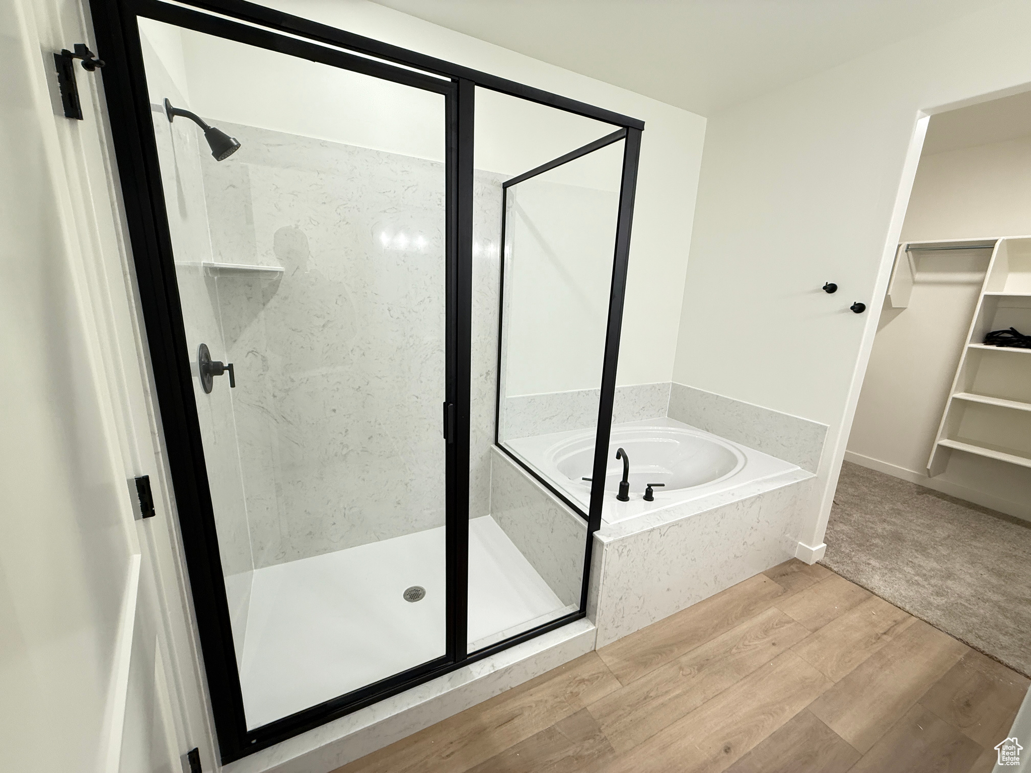 Bathroom featuring hardwood / wood-style flooring and shower with separate bathtub