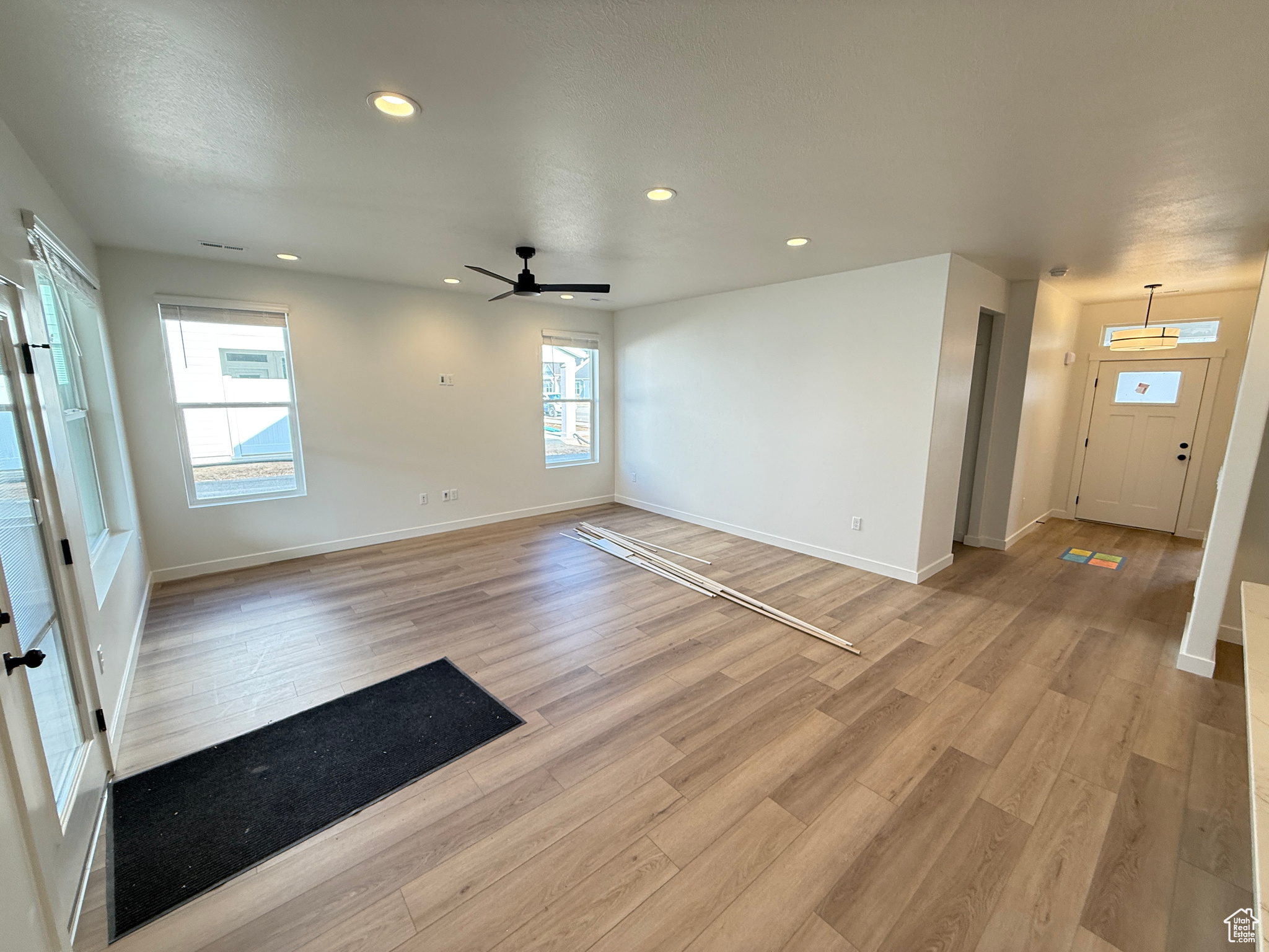 Empty room with light hardwood / wood-style flooring and ceiling fan