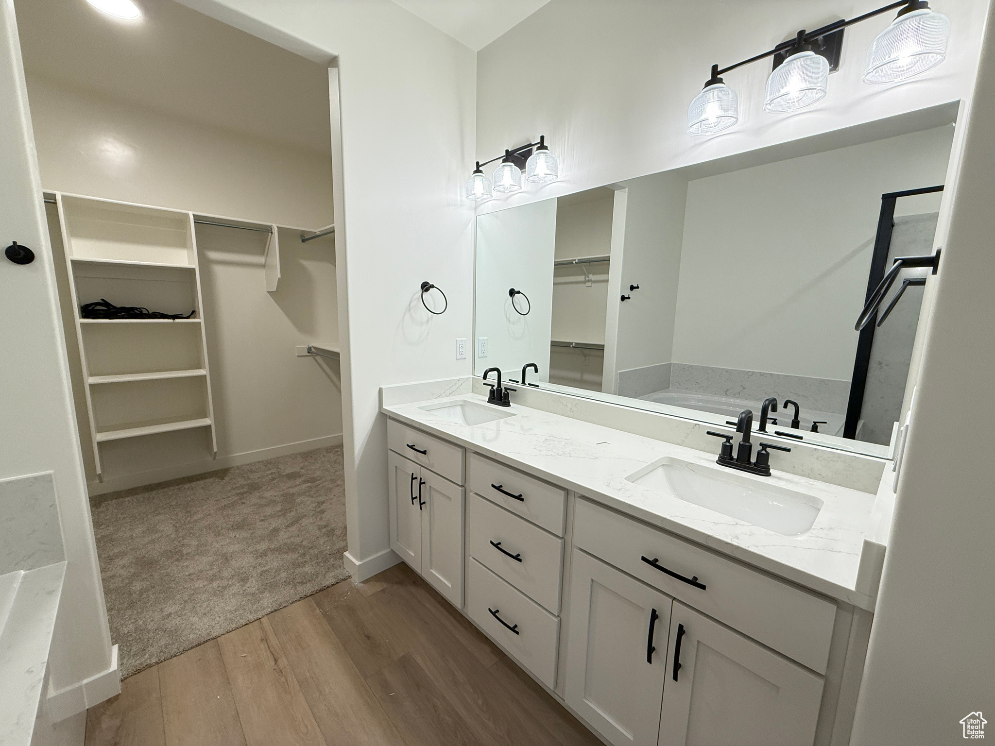 Bathroom with a bathtub, vanity, and wood-type flooring