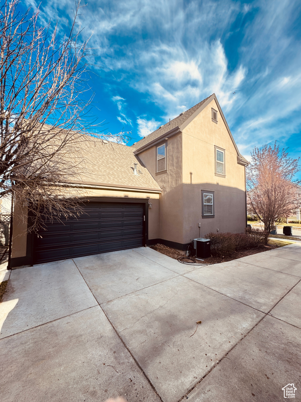 View of property exterior with a garage and central AC