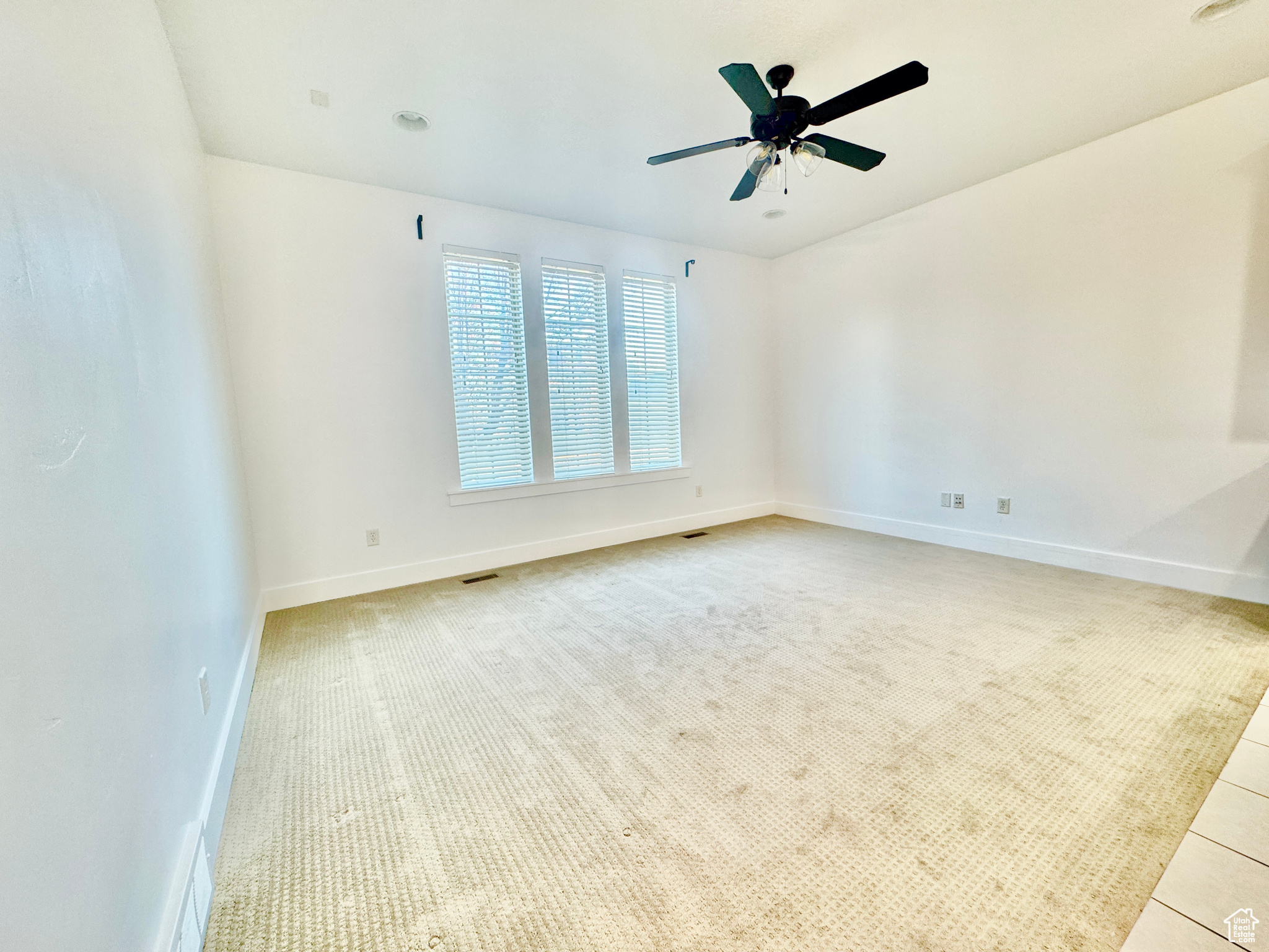 Unfurnished room with light carpet and ceiling fan