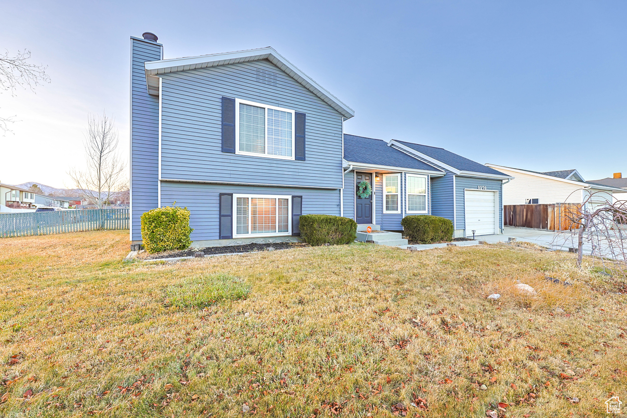 Split level home with a front yard and a garage