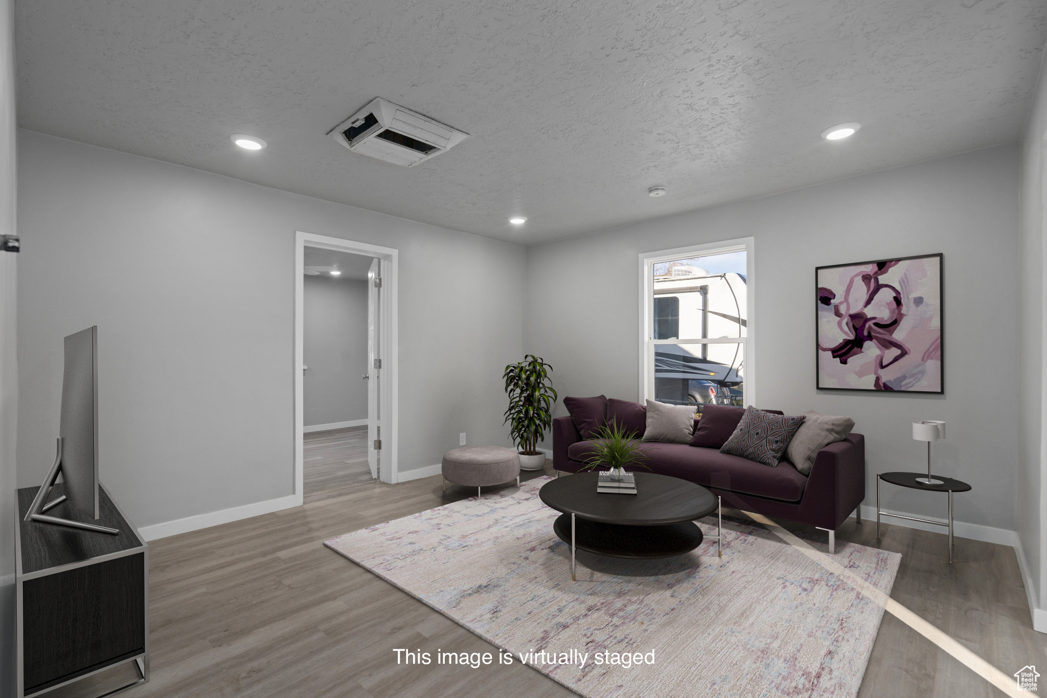 Living room featuring a textured ceiling and hardwood / wood-style flooring