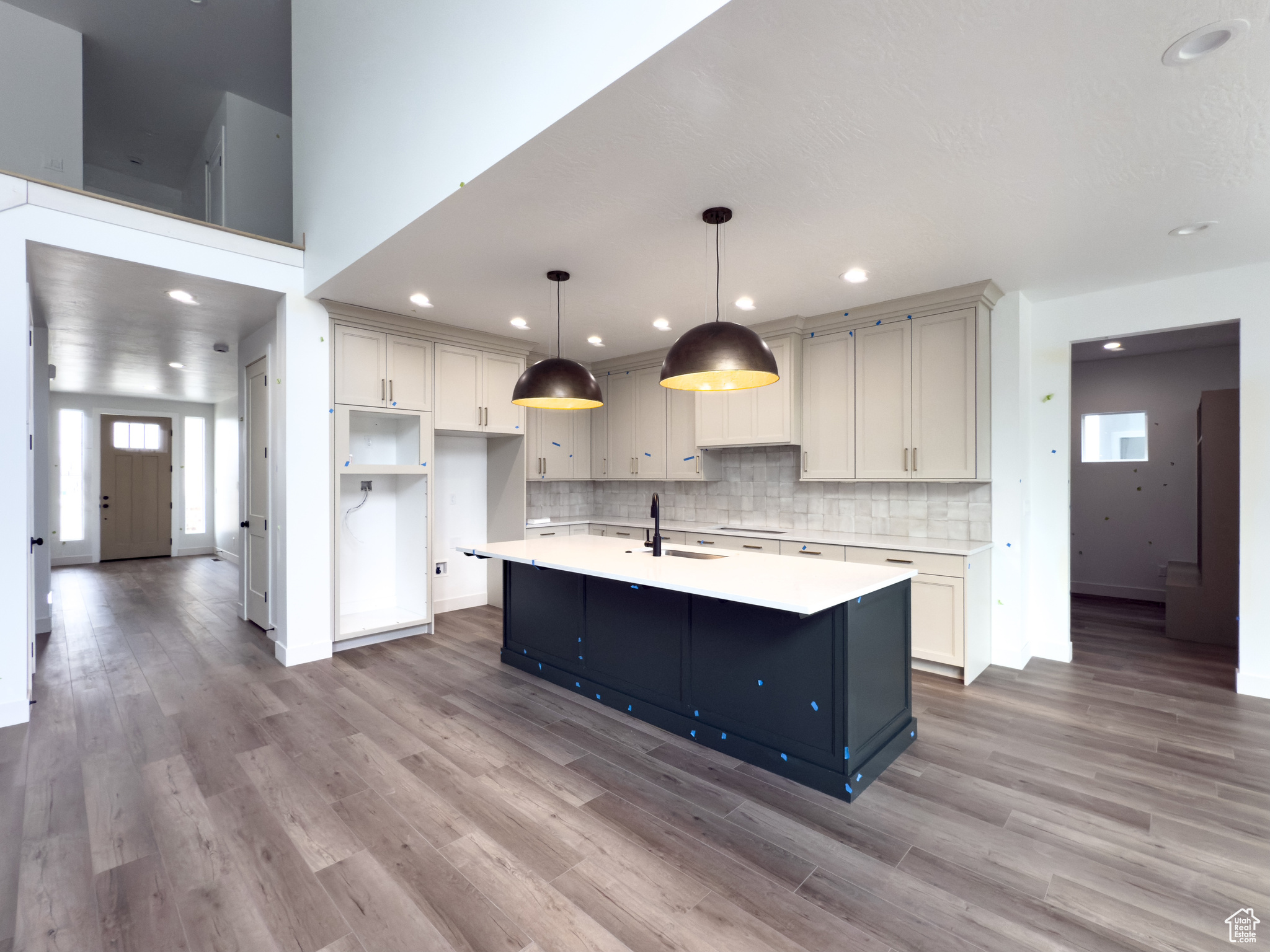 Kitchen featuring decorative light fixtures, a kitchen island with sink, and light hardwood / wood-style floors