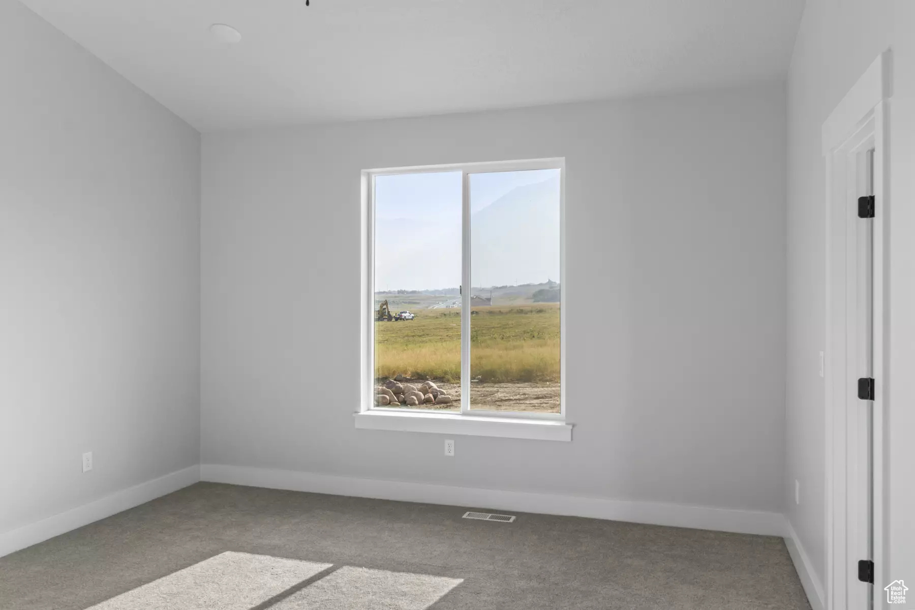 Empty room featuring light colored carpet