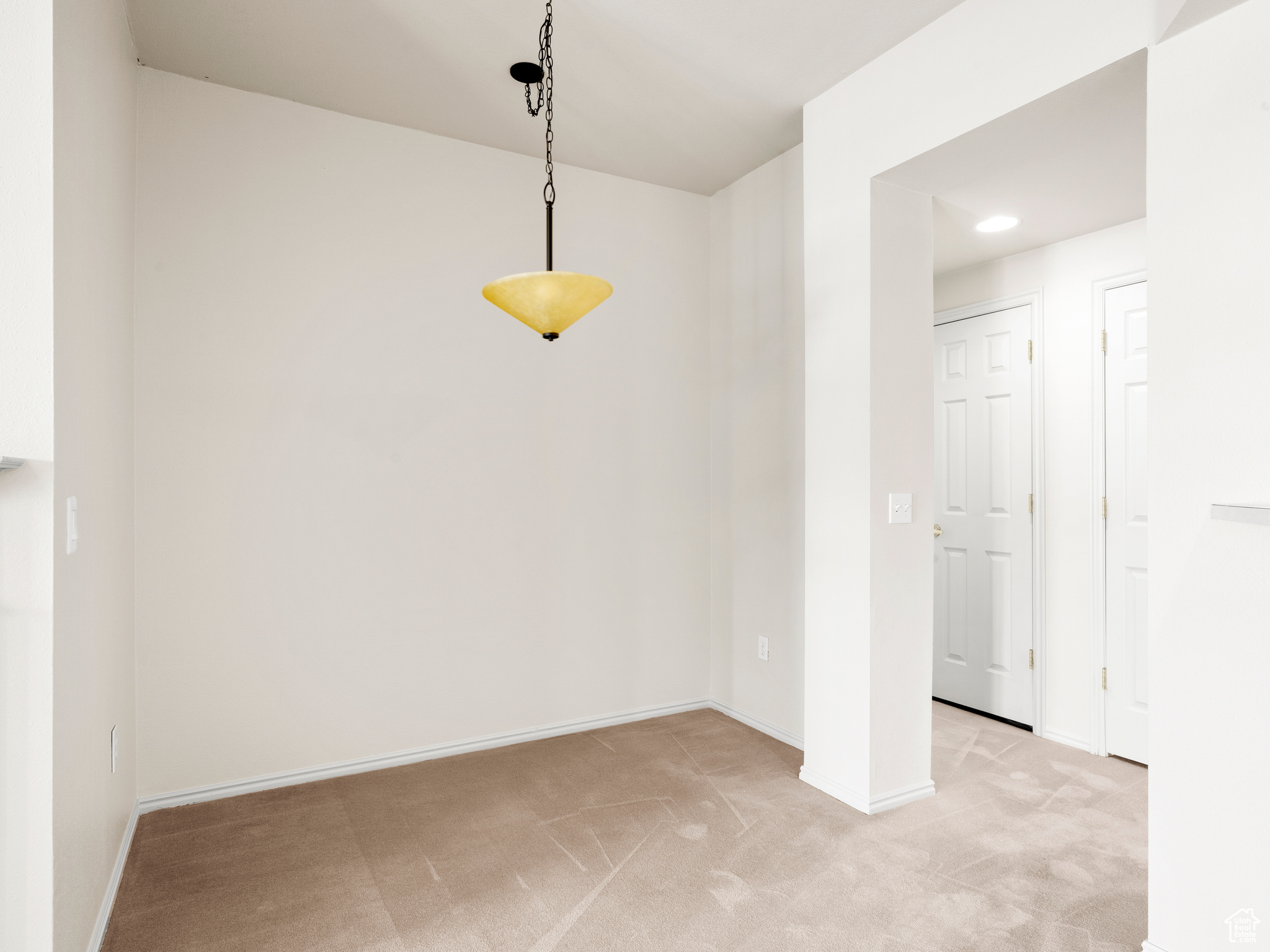 Unfurnished dining area featuring light carpet