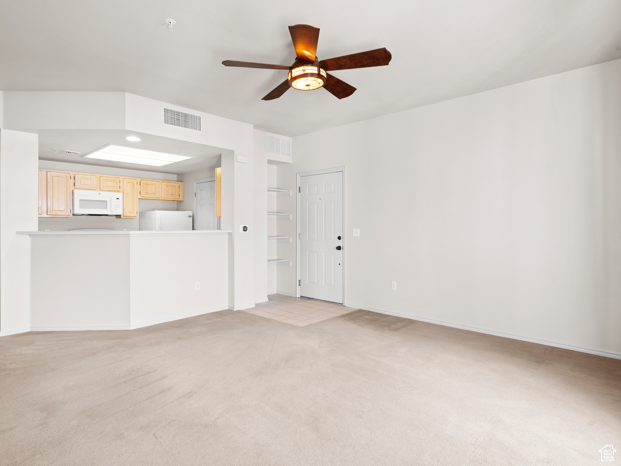 Unfurnished living room with ceiling fan and light carpet