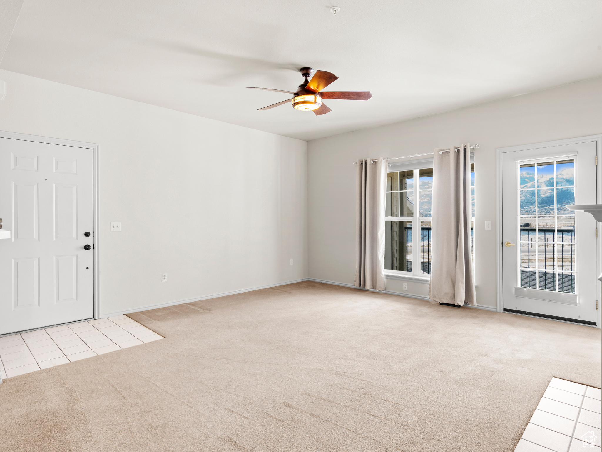 Carpeted spare room with ceiling fan