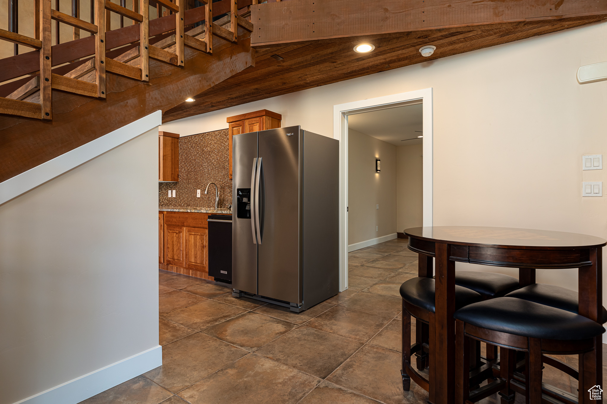 Kitchen featuring dishwasher, sink, wooden ceiling, stainless steel fridge with ice dispenser, and backsplash