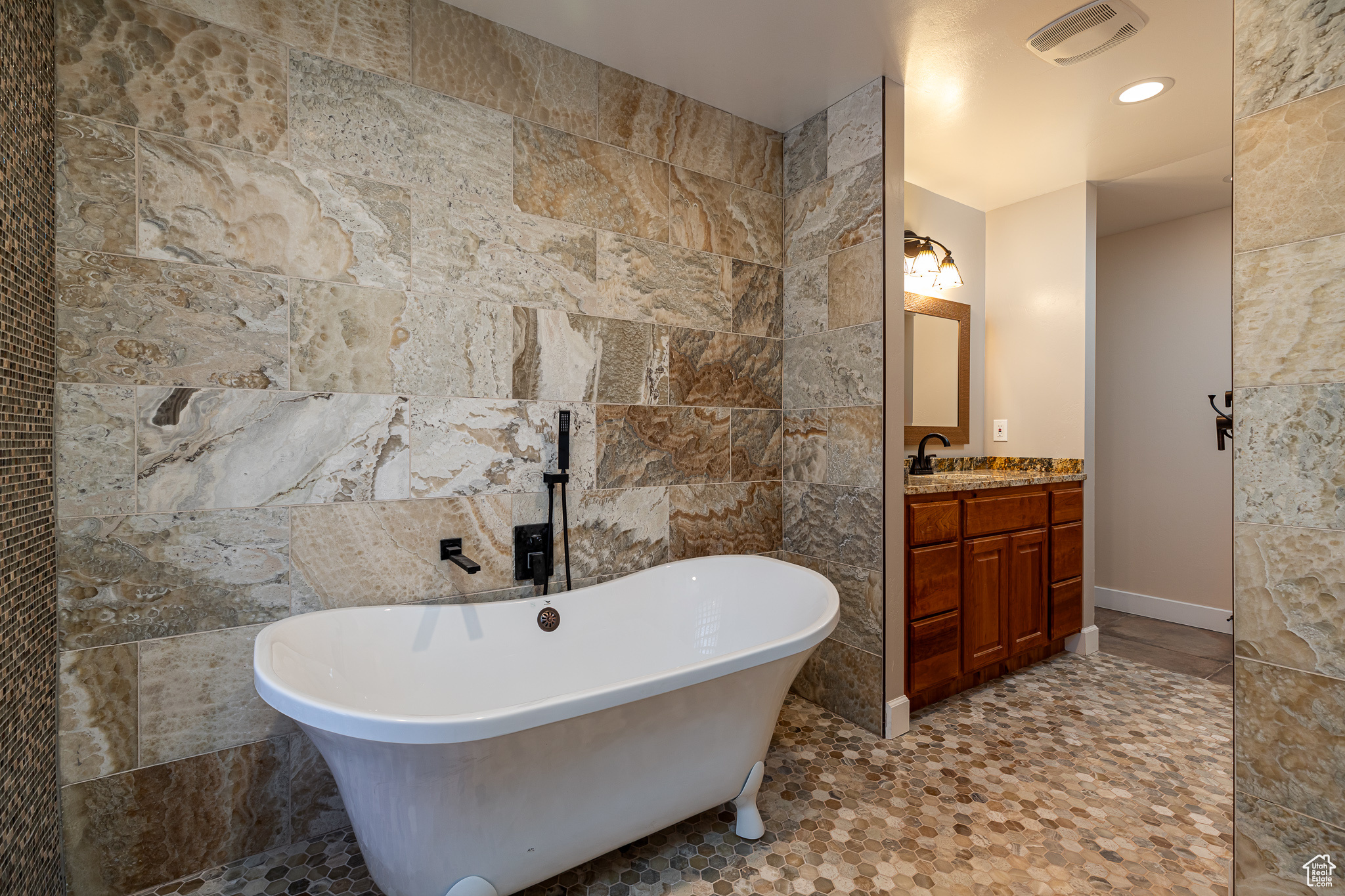 Master bedroom #1 Bathroom featuring vanity, tile walls, and a tub