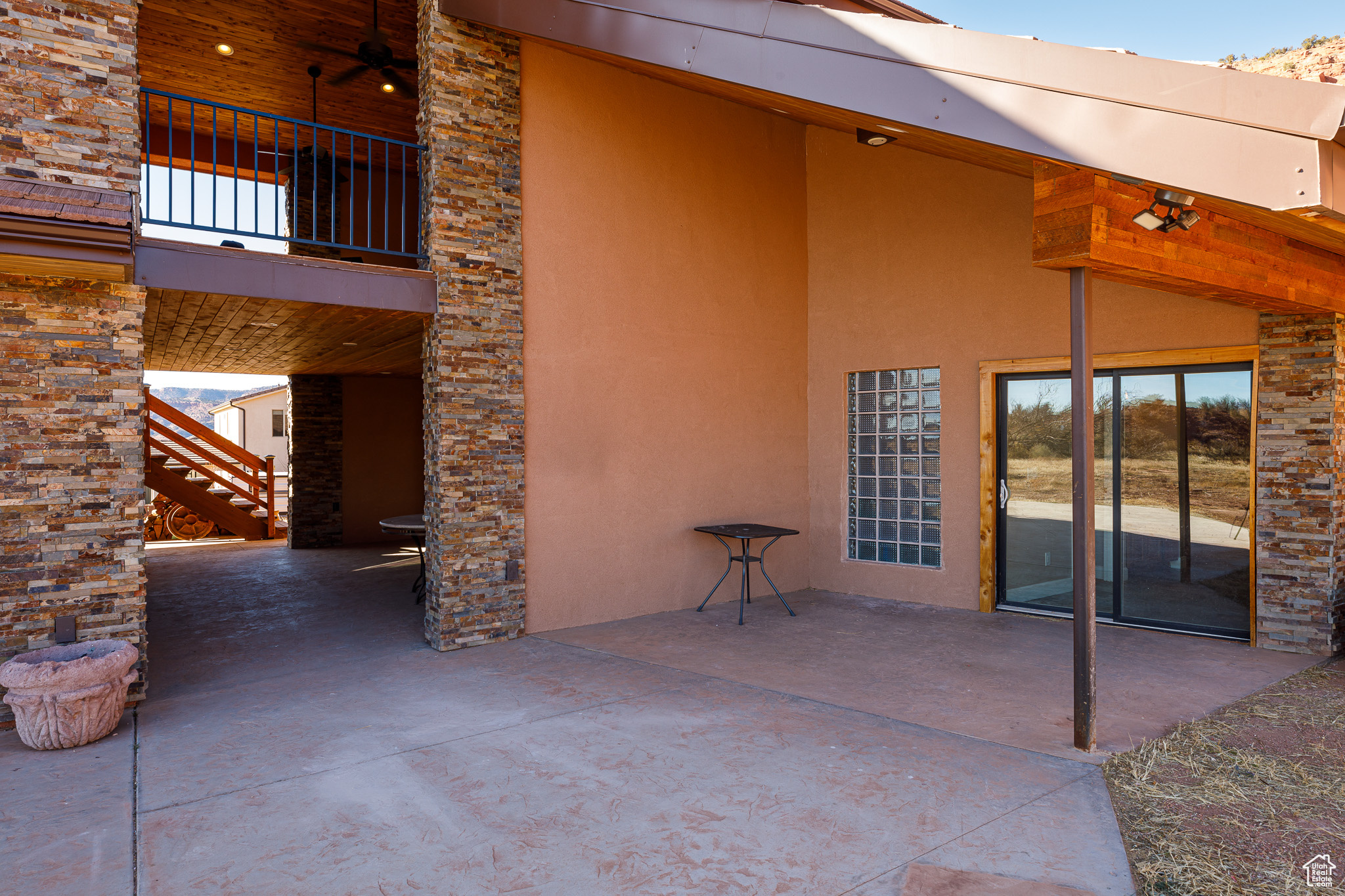 View of patio with ceiling fan and a balcony