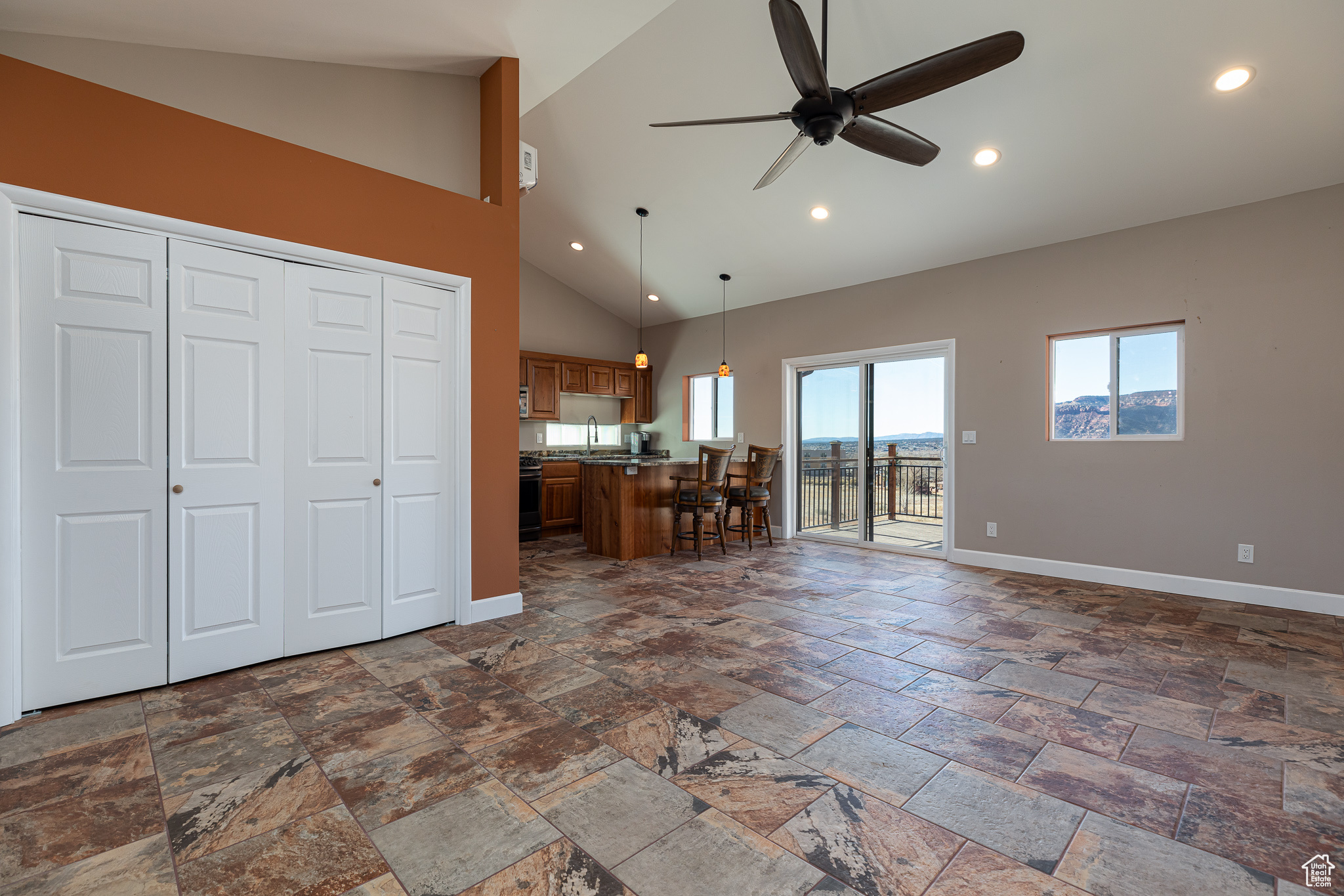 Studio living room featuring ceiling fan, sink, and high vaulted ceiling