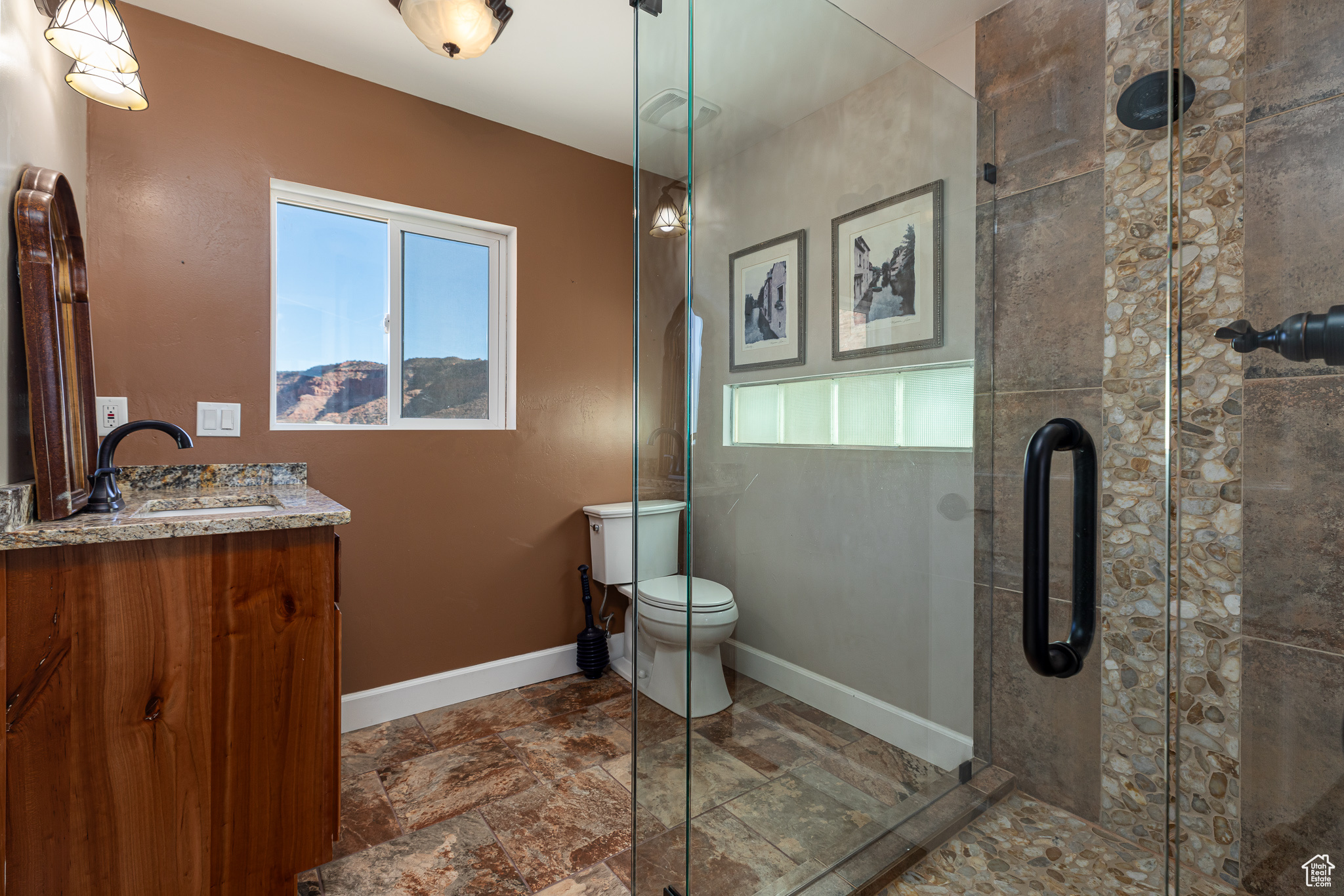 Bathroom with vanity, toilet, and an enclosed shower