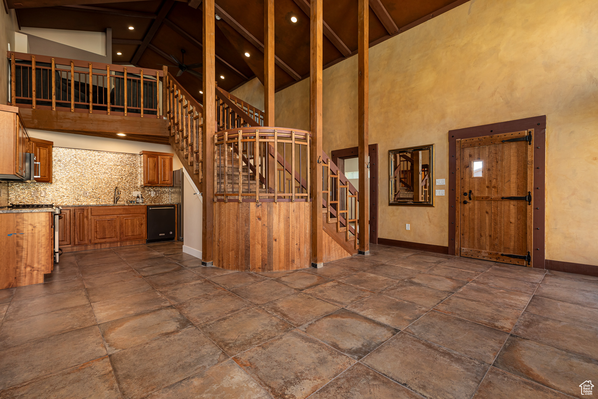 Interior space with beam ceiling, sink, and high vaulted ceiling