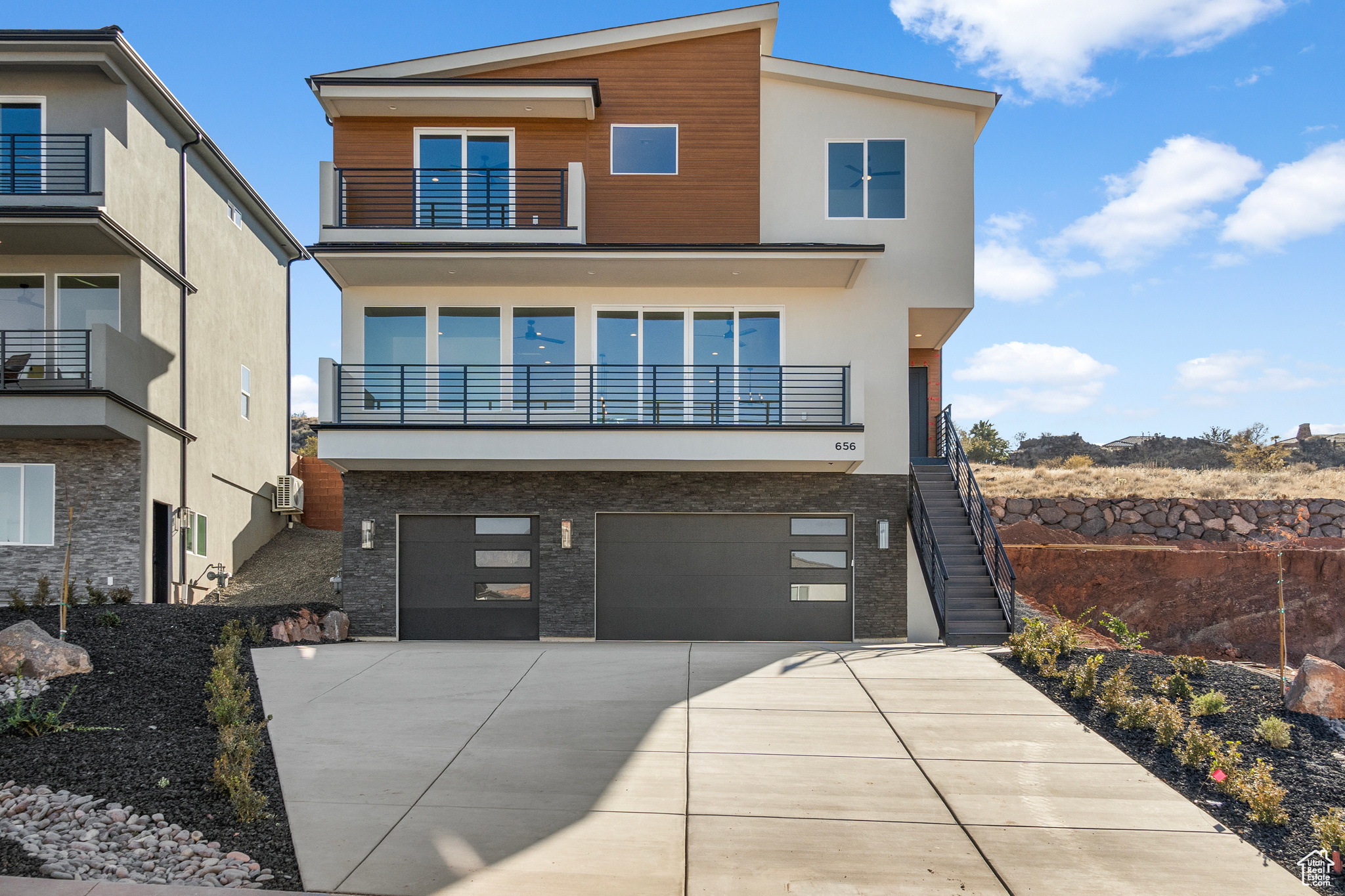 Contemporary home featuring a balcony and a garage