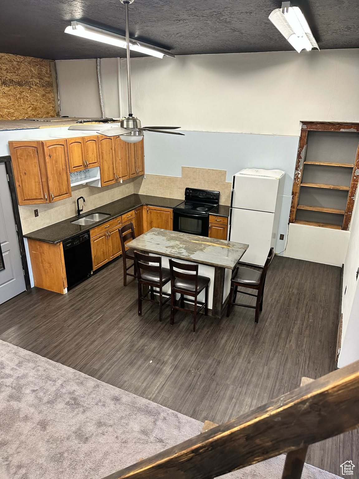 Kitchen featuring backsplash, sink, black appliances, and dark hardwood / wood-style floors