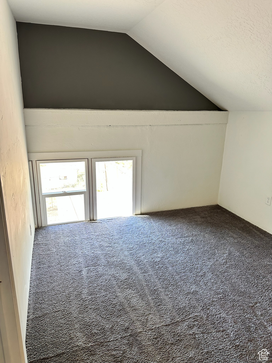 Additional living space with carpet floors and lofted ceiling