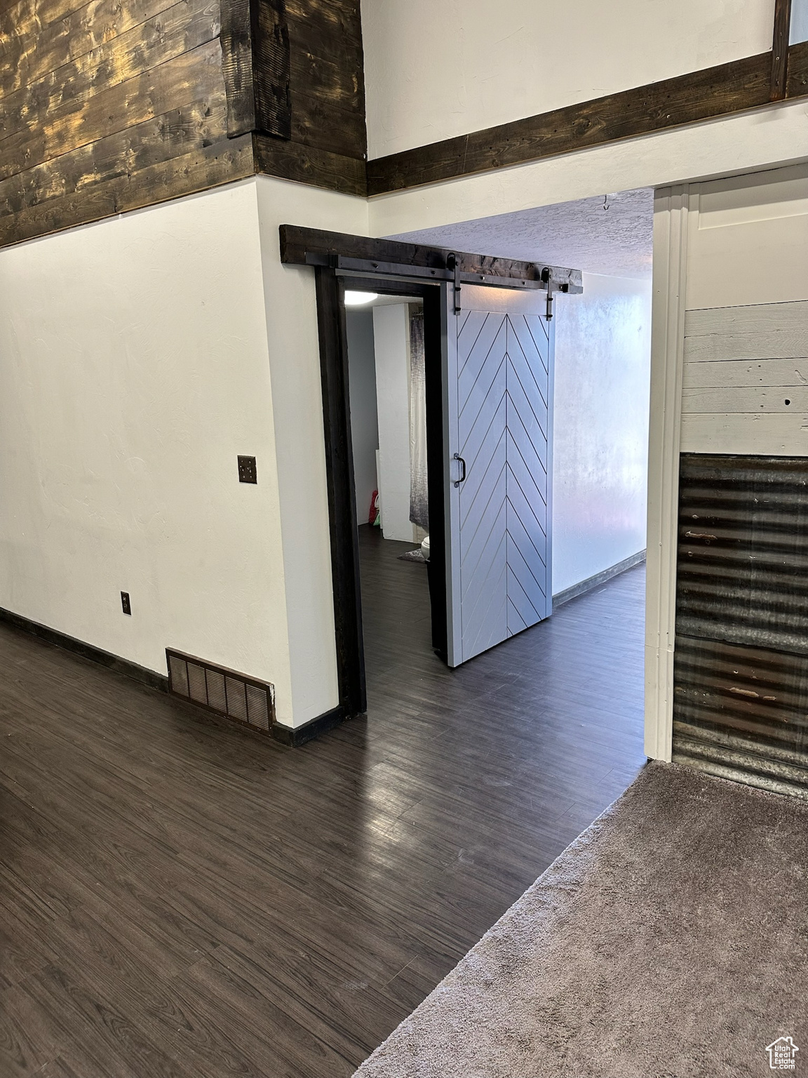 Spare room with dark hardwood / wood-style flooring and a barn door