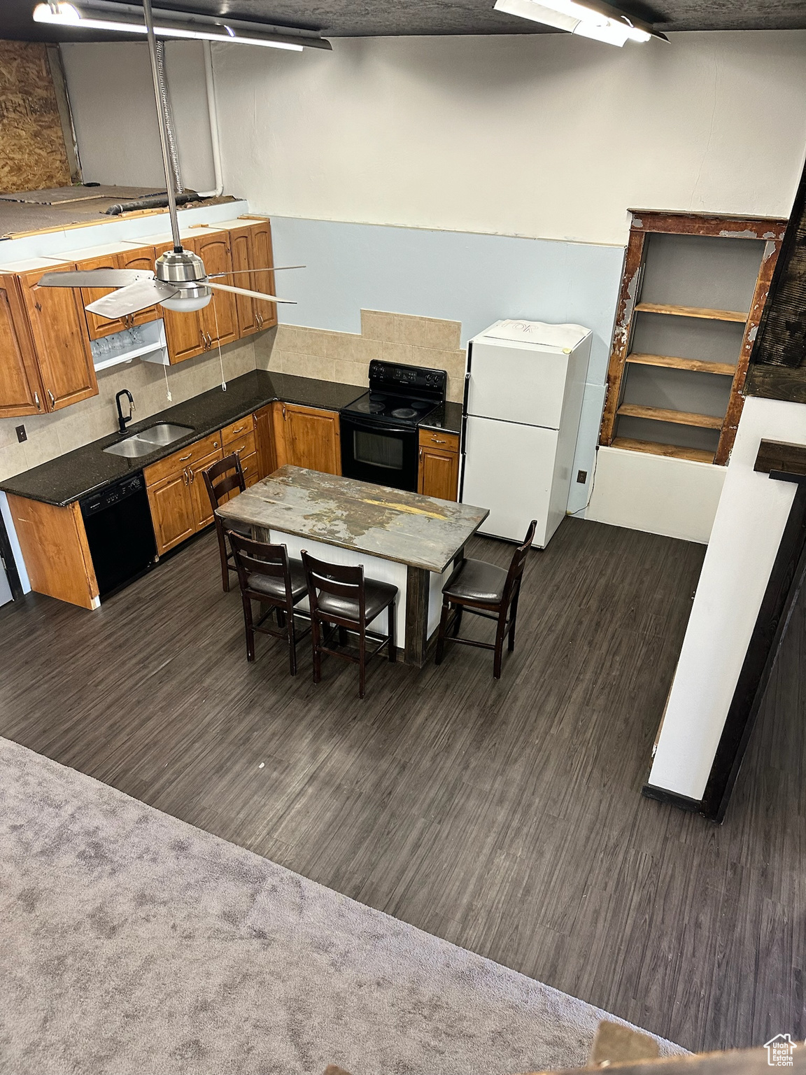 Kitchen with dark colored carpet, sink, and black appliances