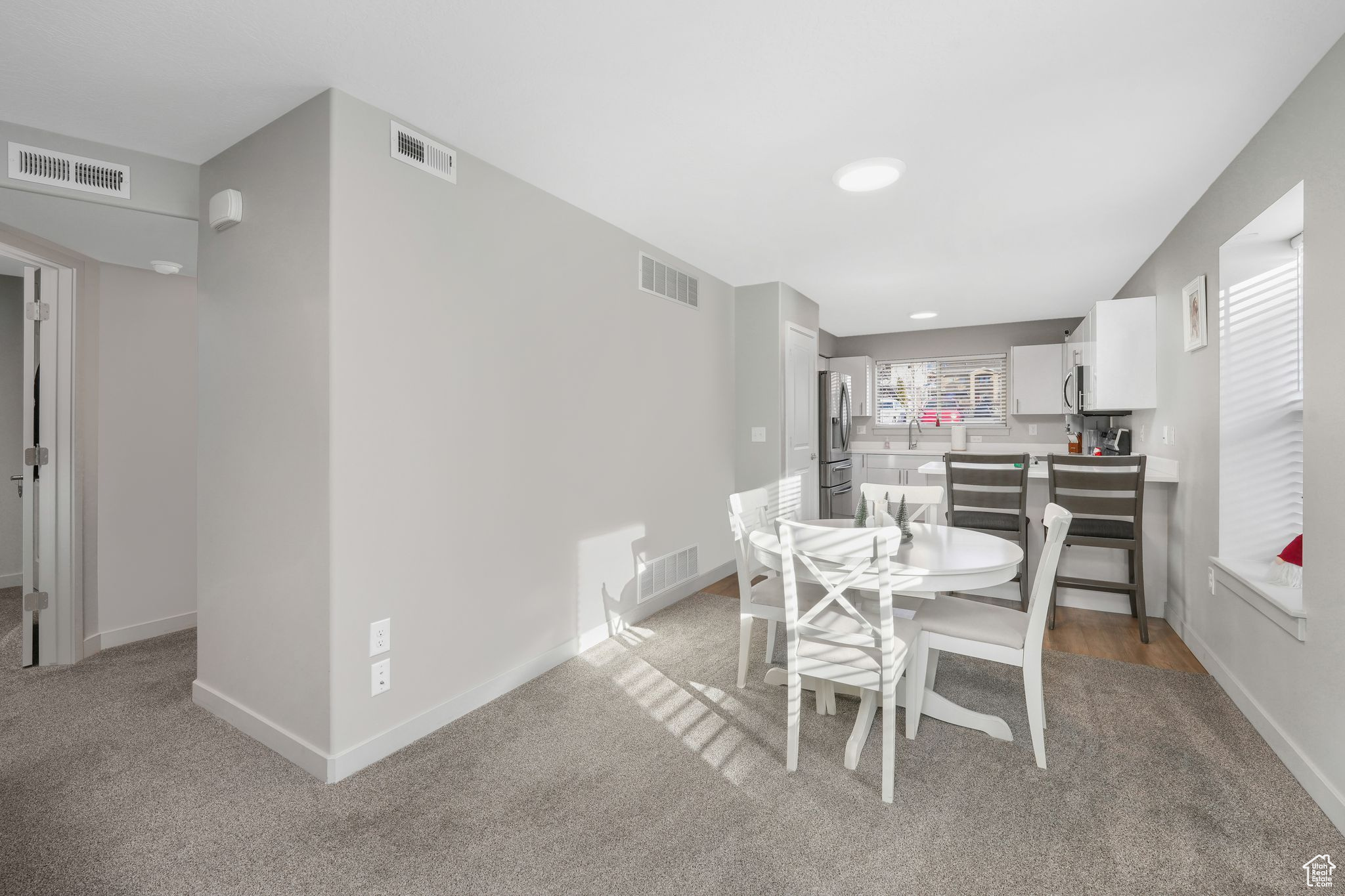 Dining space with light carpet and sink