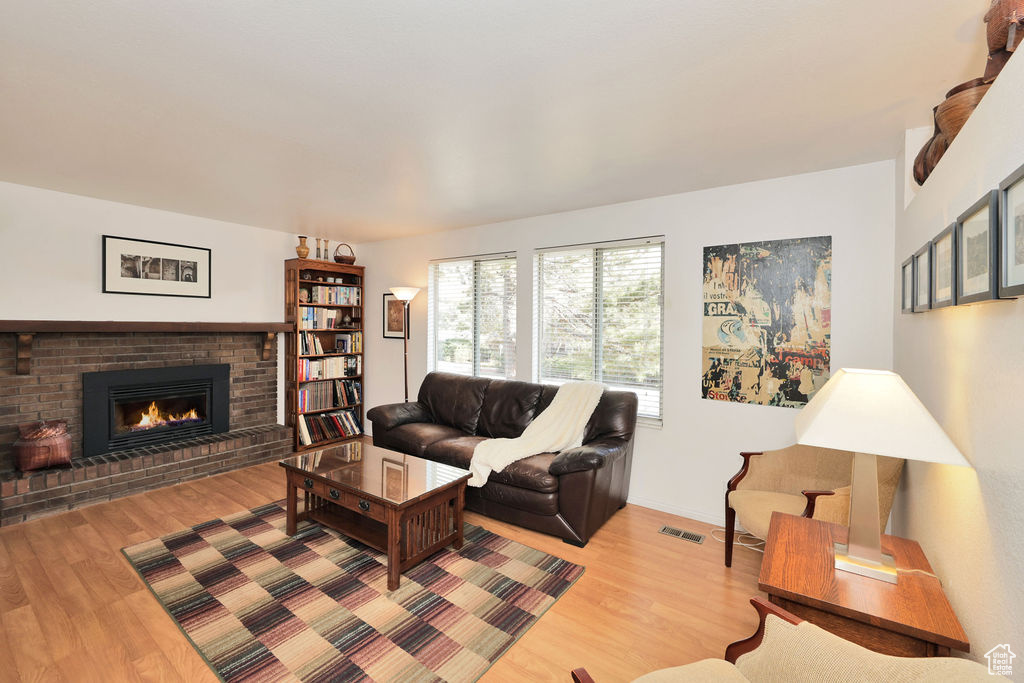 Living room with light hardwood / wood-style floors and a fireplace