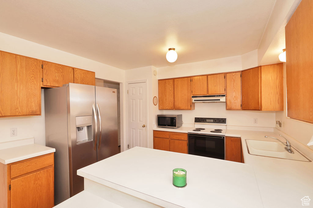 Kitchen featuring kitchen peninsula, stainless steel appliances, and sink