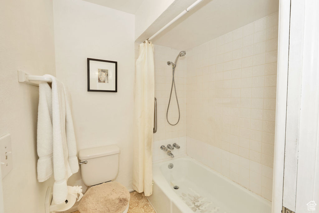 Bathroom with shower / tub combo with curtain and toilet