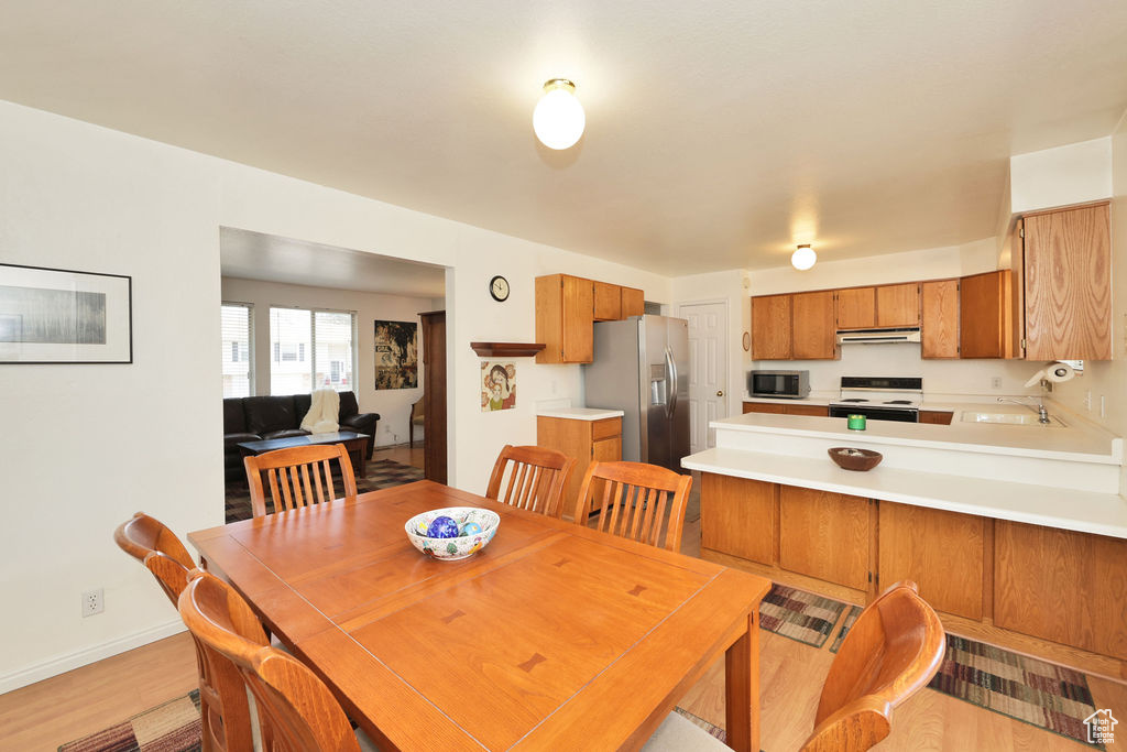 Dining space with sink and light hardwood / wood-style flooring