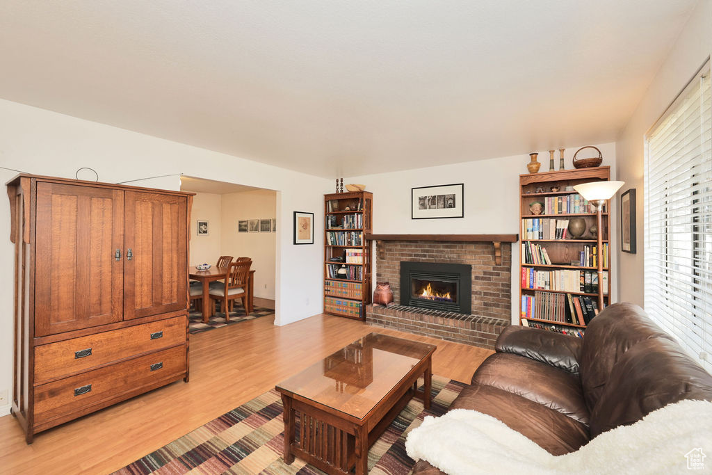 Living room featuring light hardwood / wood-style floors and a brick fireplace