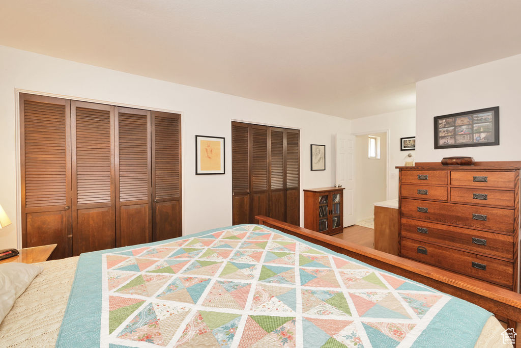 Bedroom with hardwood / wood-style flooring and multiple closets