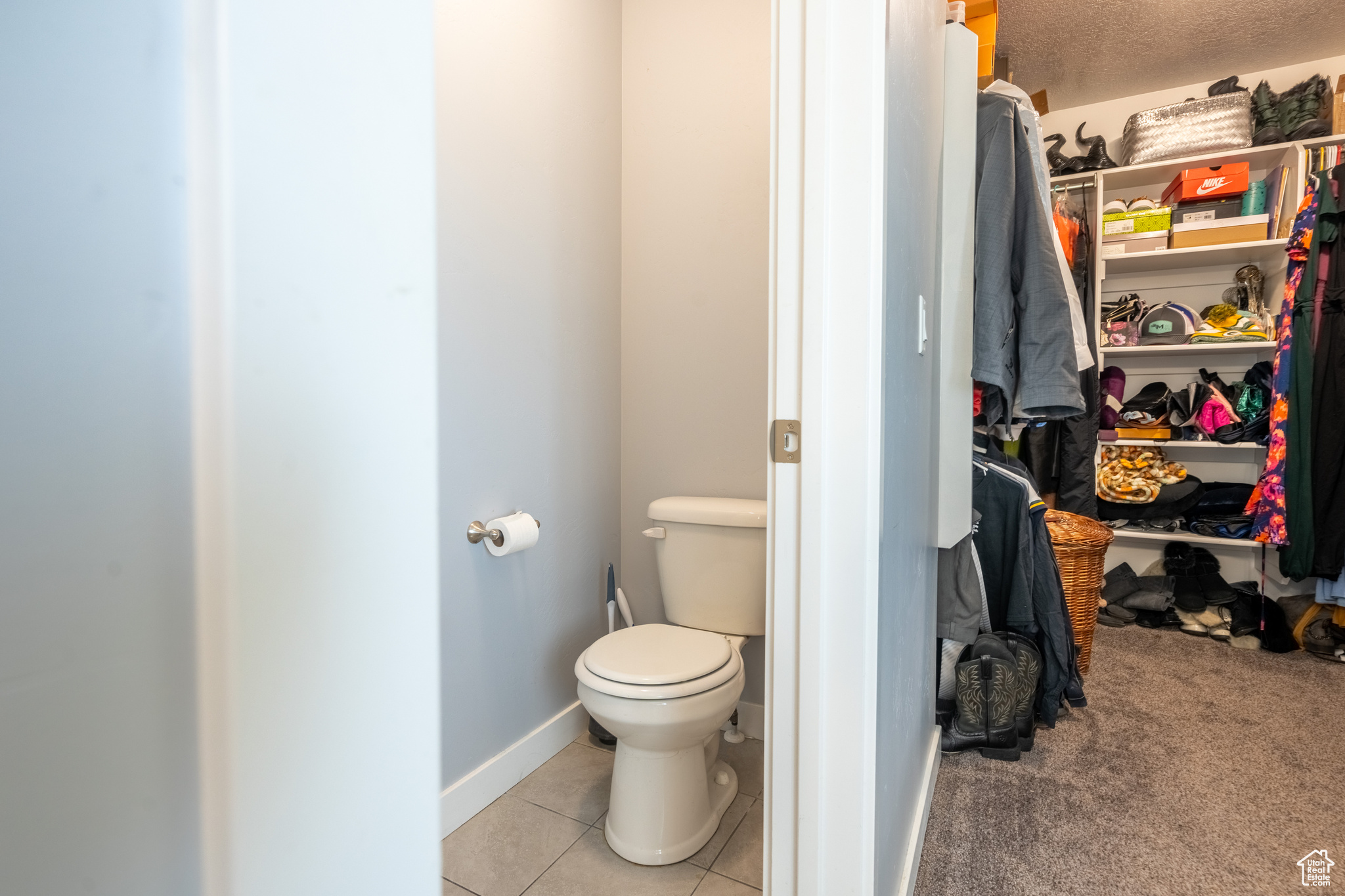 Bathroom featuring tile patterned flooring, a textured ceiling, and toilet