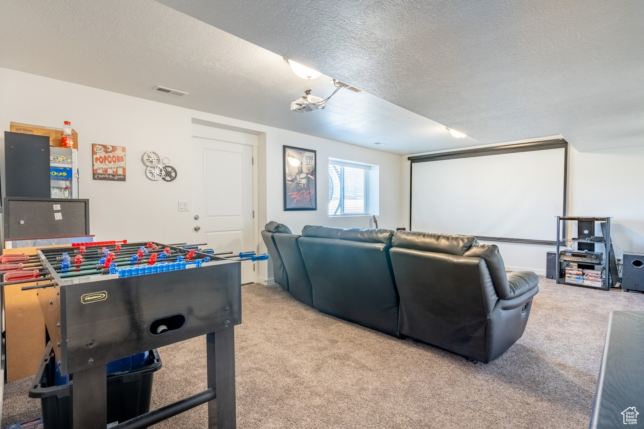 Carpeted cinema room featuring a textured ceiling