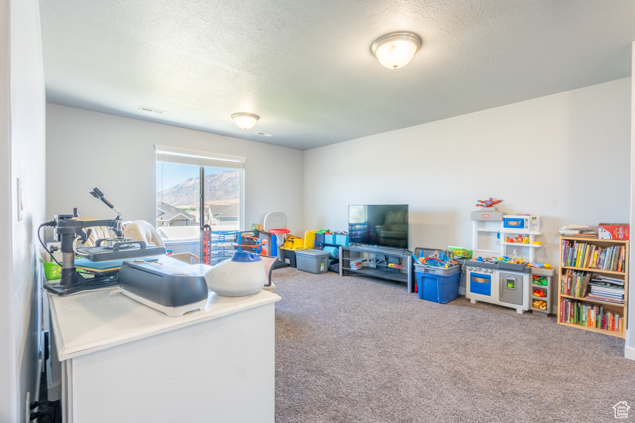 Playroom with carpet and a textured ceiling