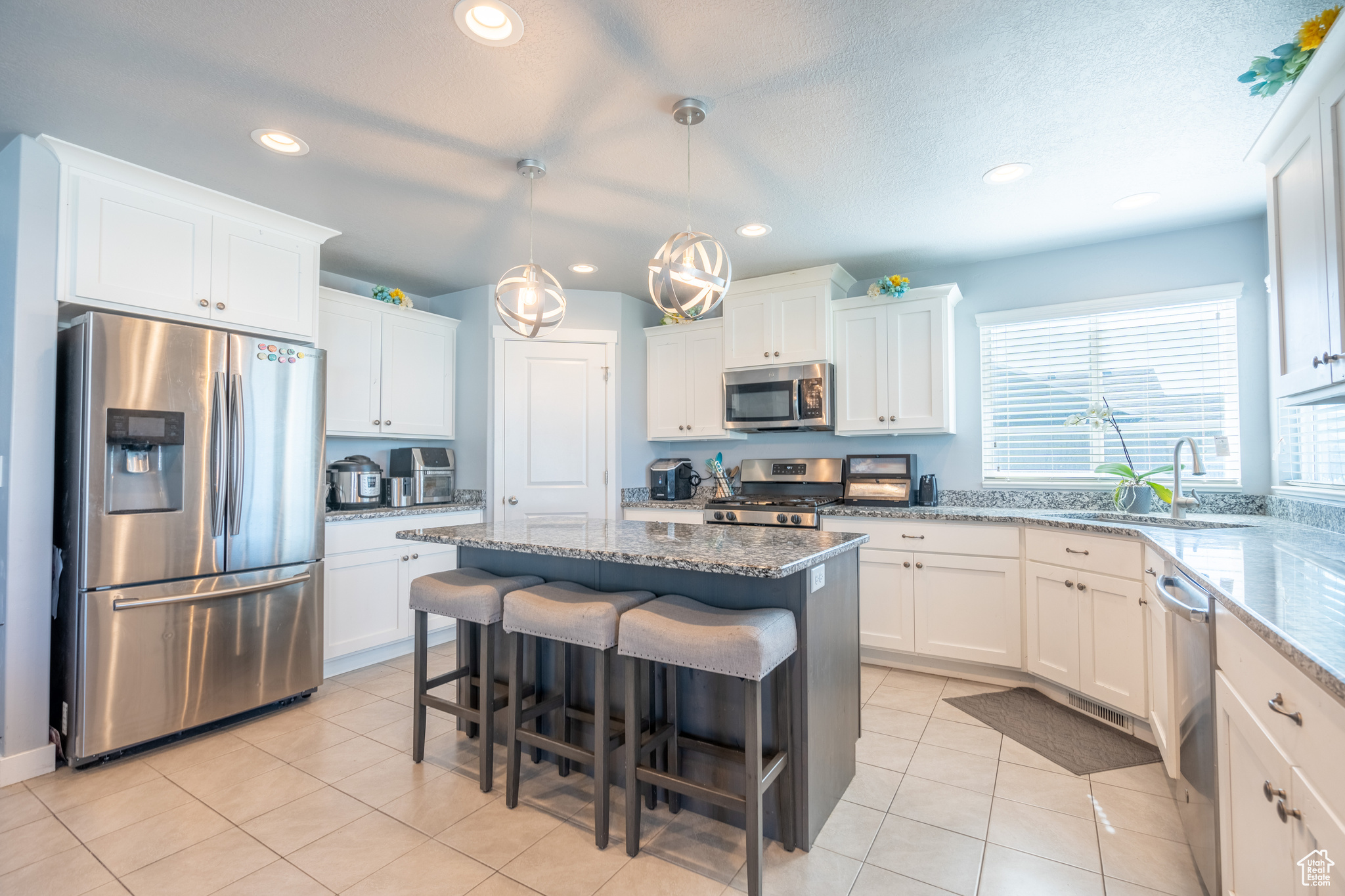 Kitchen with sink, white cabinets, and appliances with stainless steel finishes